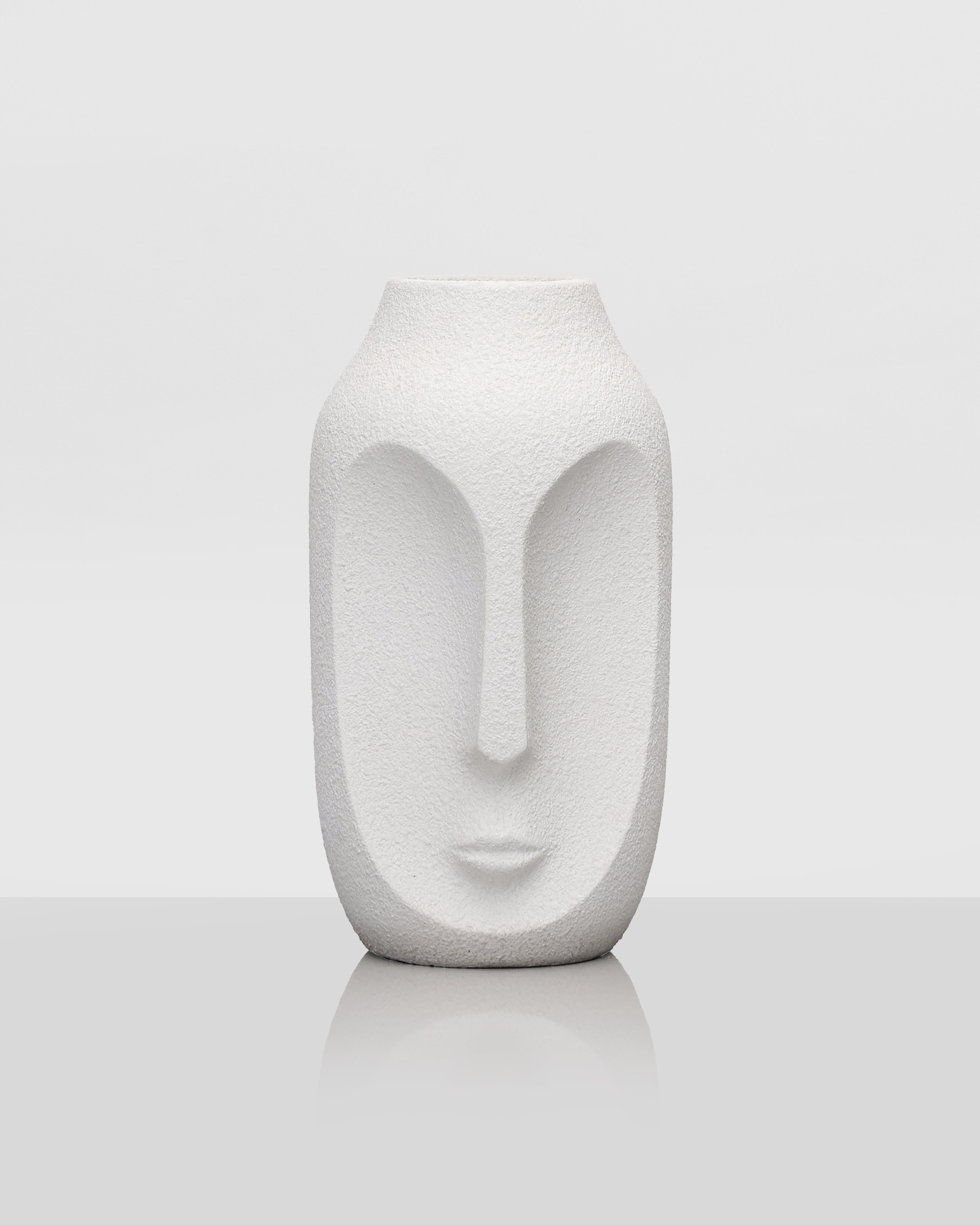 White ceramic vase with face design on a white background