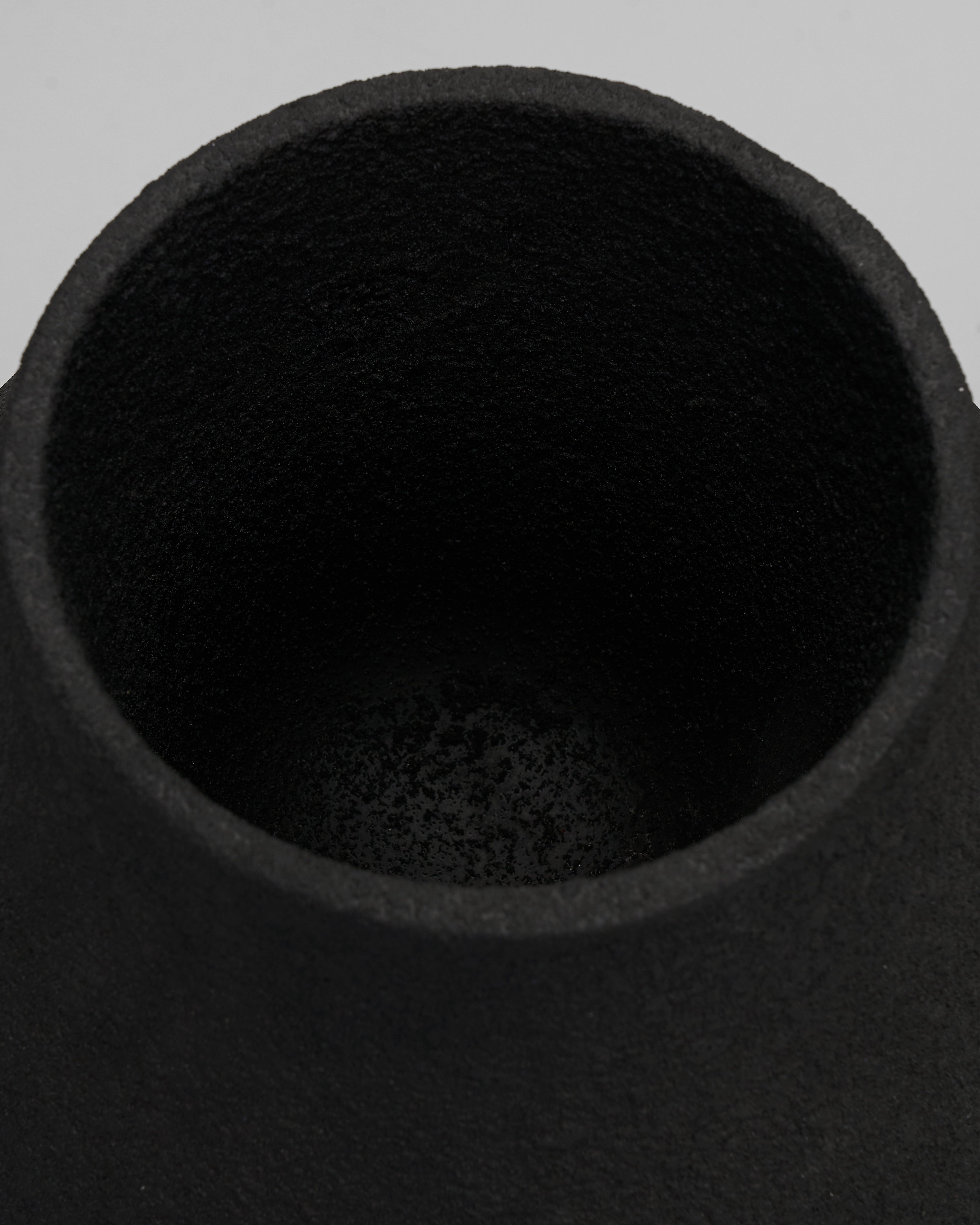 Close-up of a black ceramic vase on a gray background
