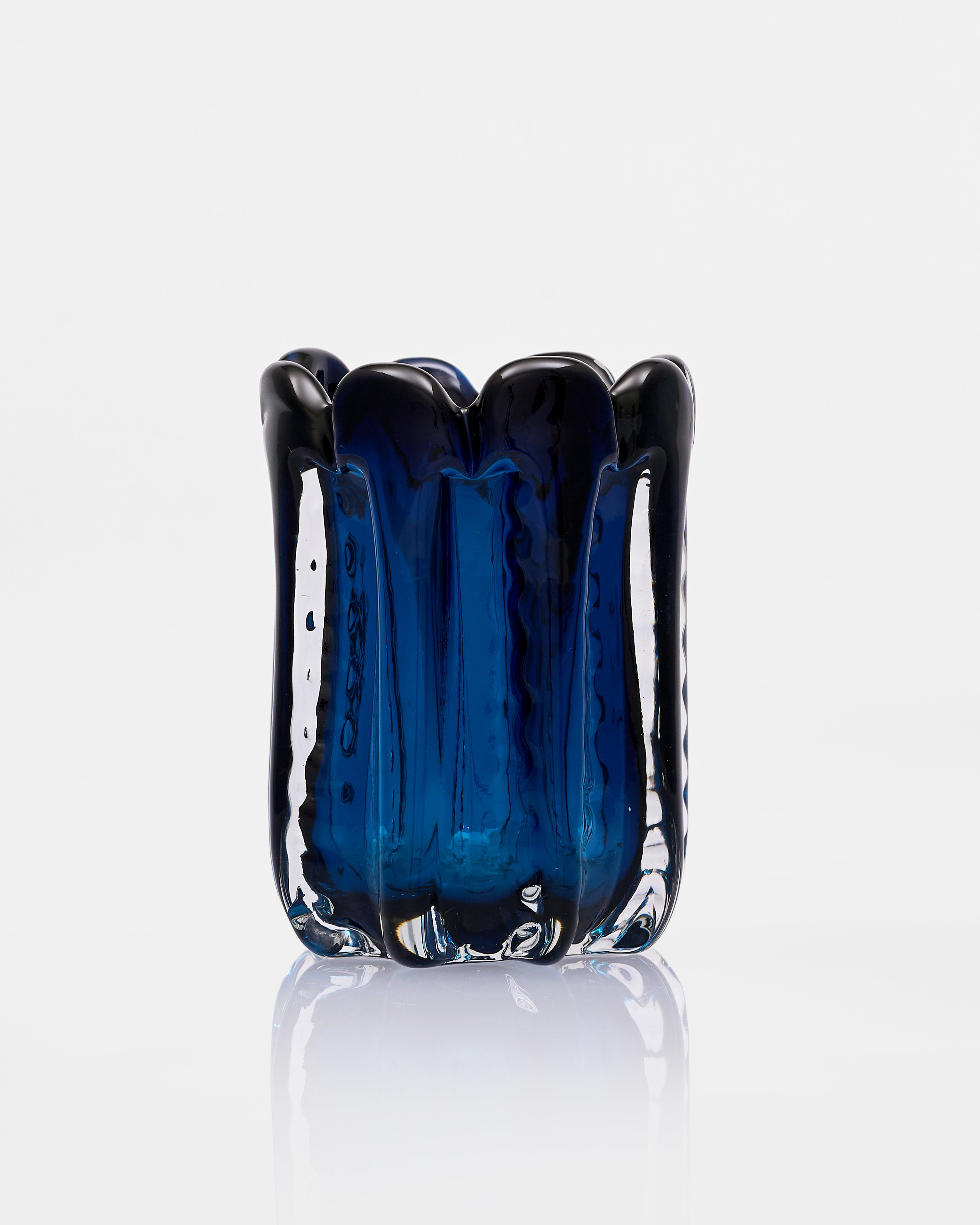 Blue glass vase with a textured surface on a white background