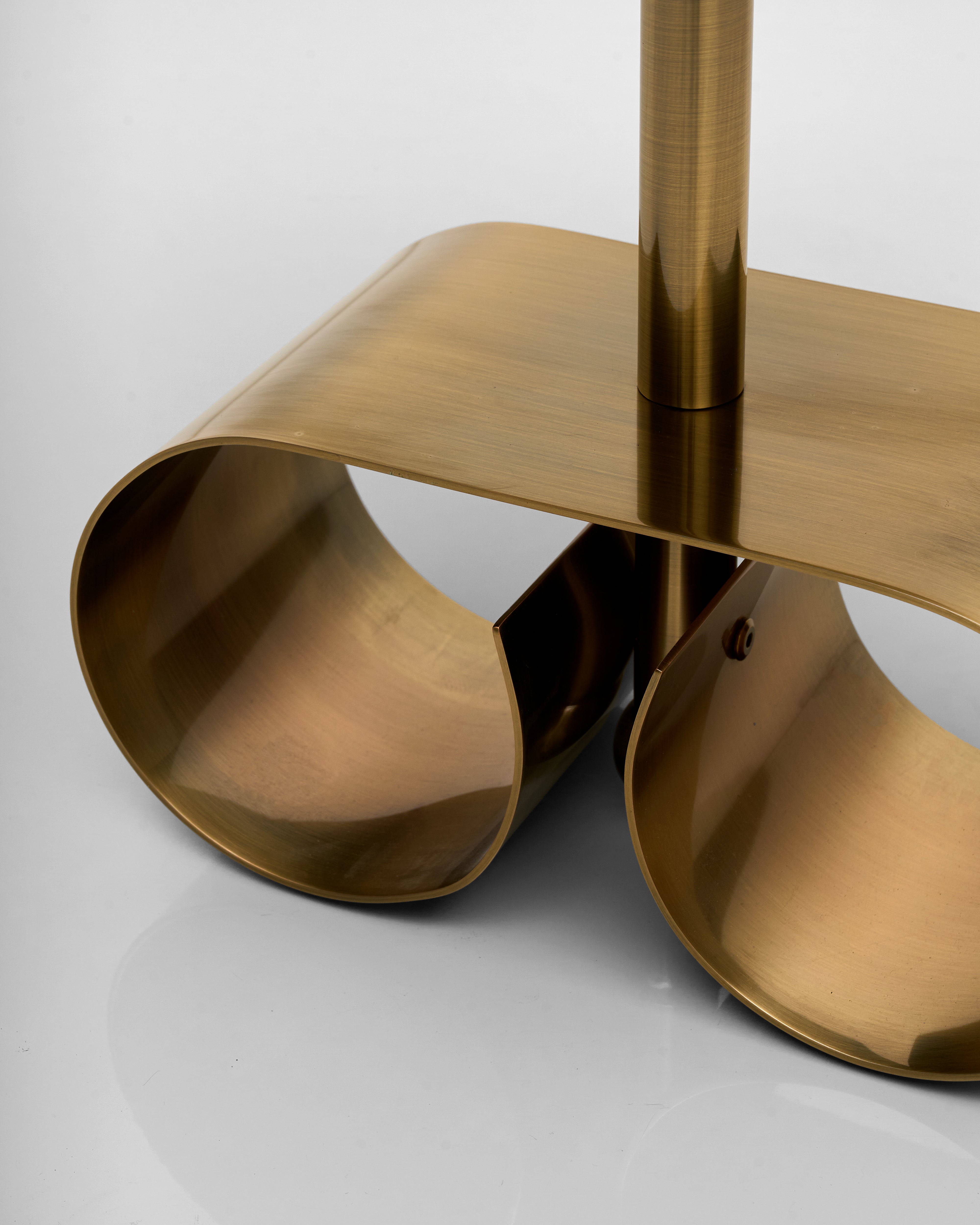 Gold metal side table leg with a modern design on a white background
