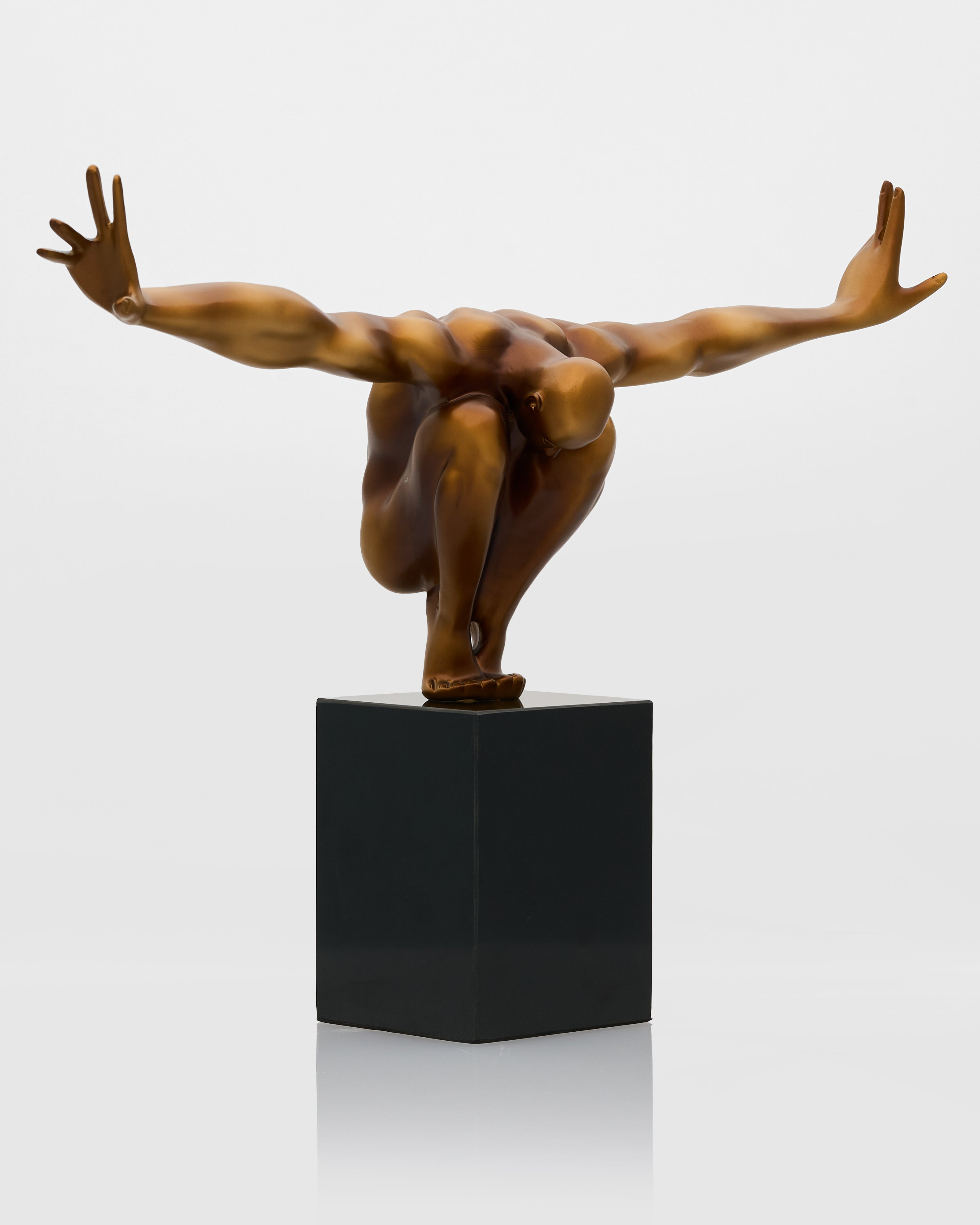 Bronze sculpture of a dancer on a black cube base against a white background