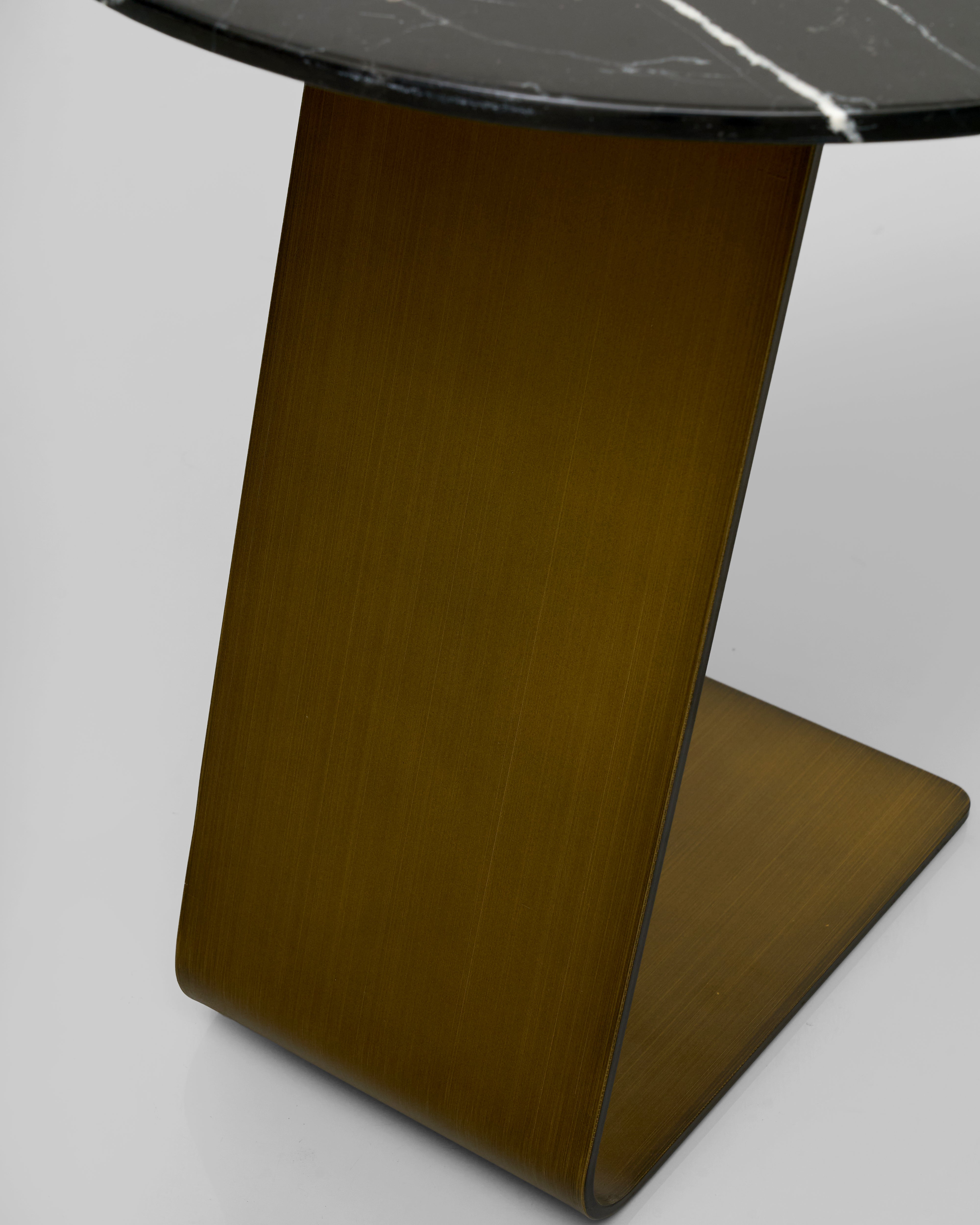 Stinless steel leg side table with a marble top on a light gray background