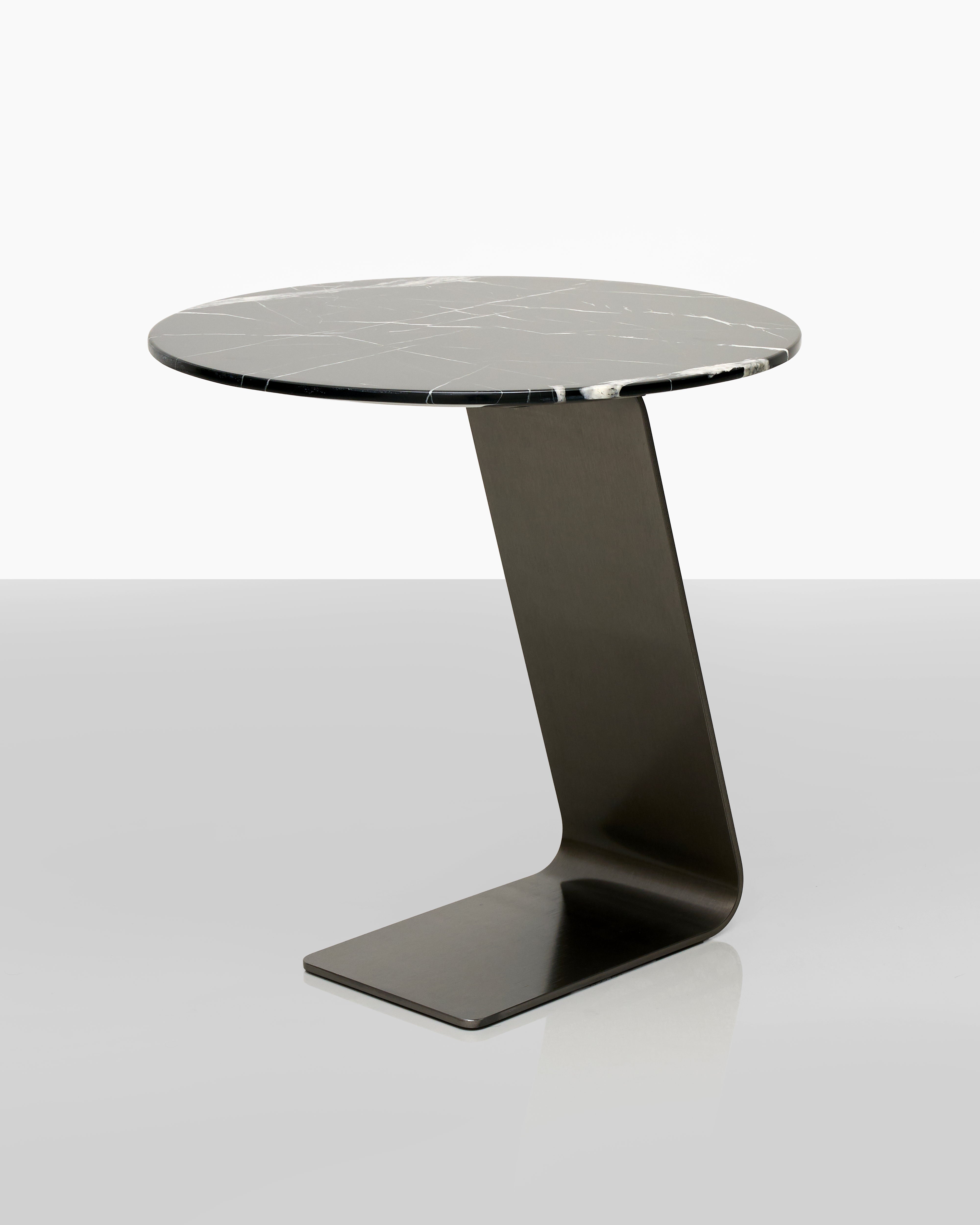 Modern side table with a black marble top and unique base design on a white background