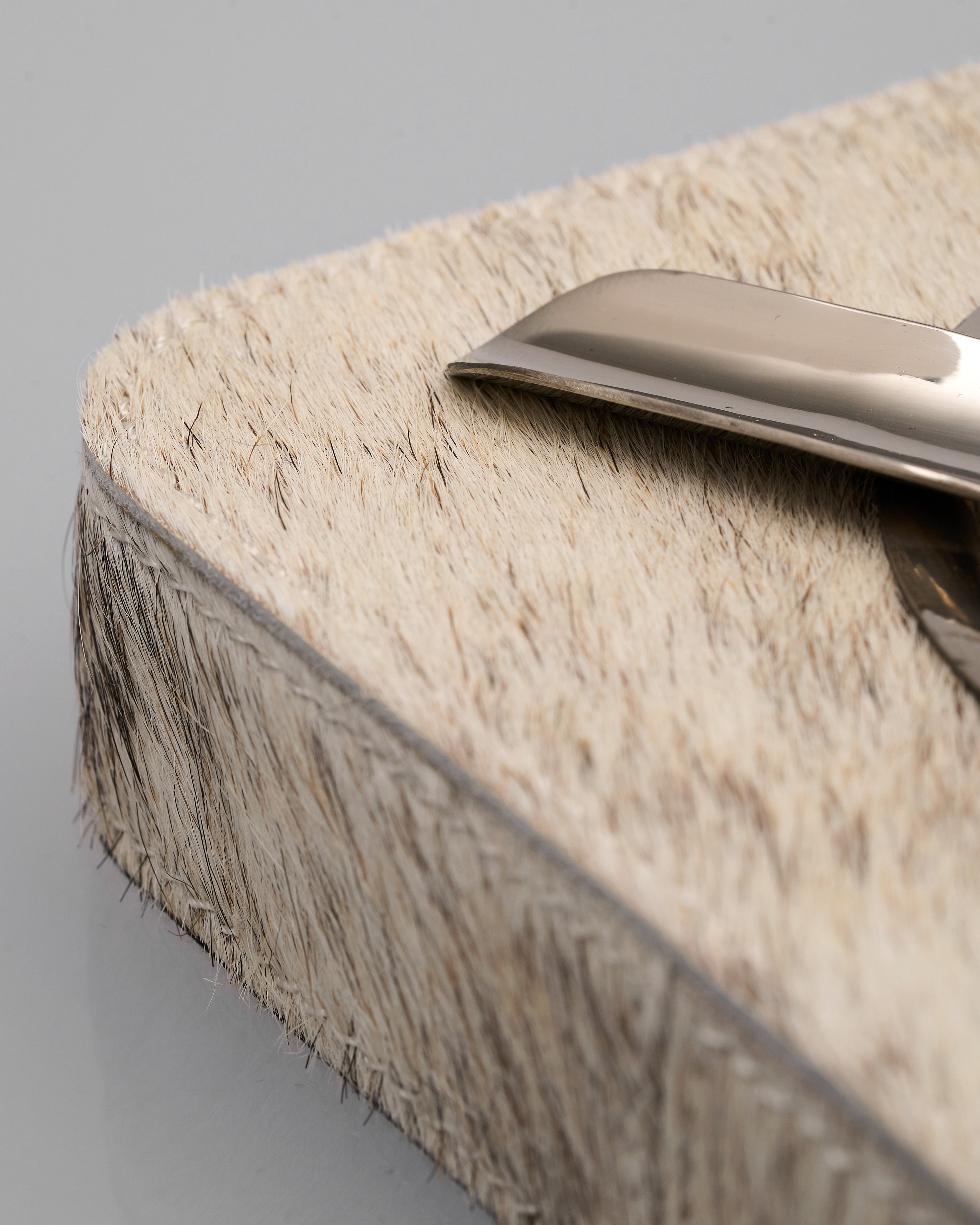 Metallic object on a textured surface with a neutral background