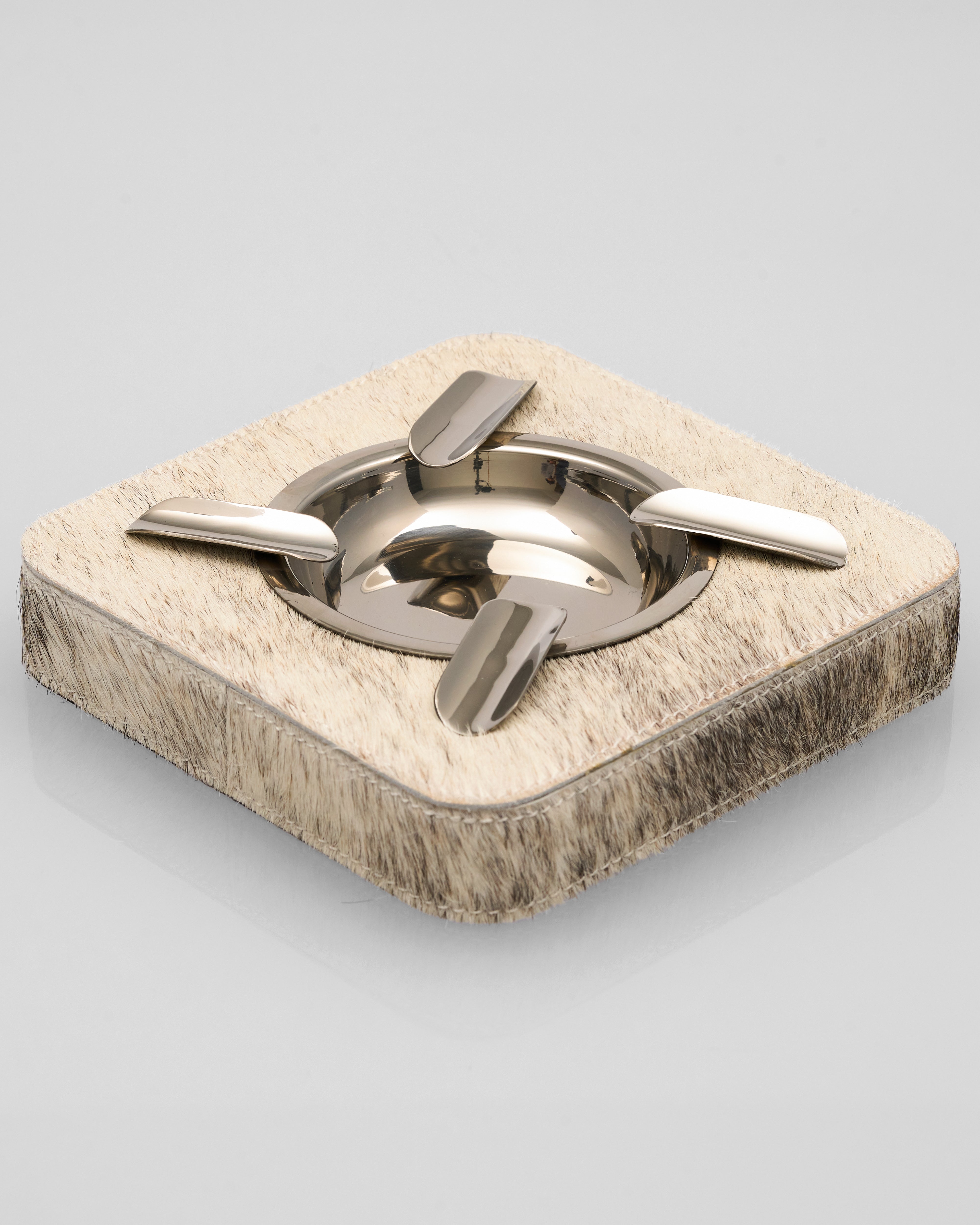 Square stone ashtray with metallic interior on a light gray background