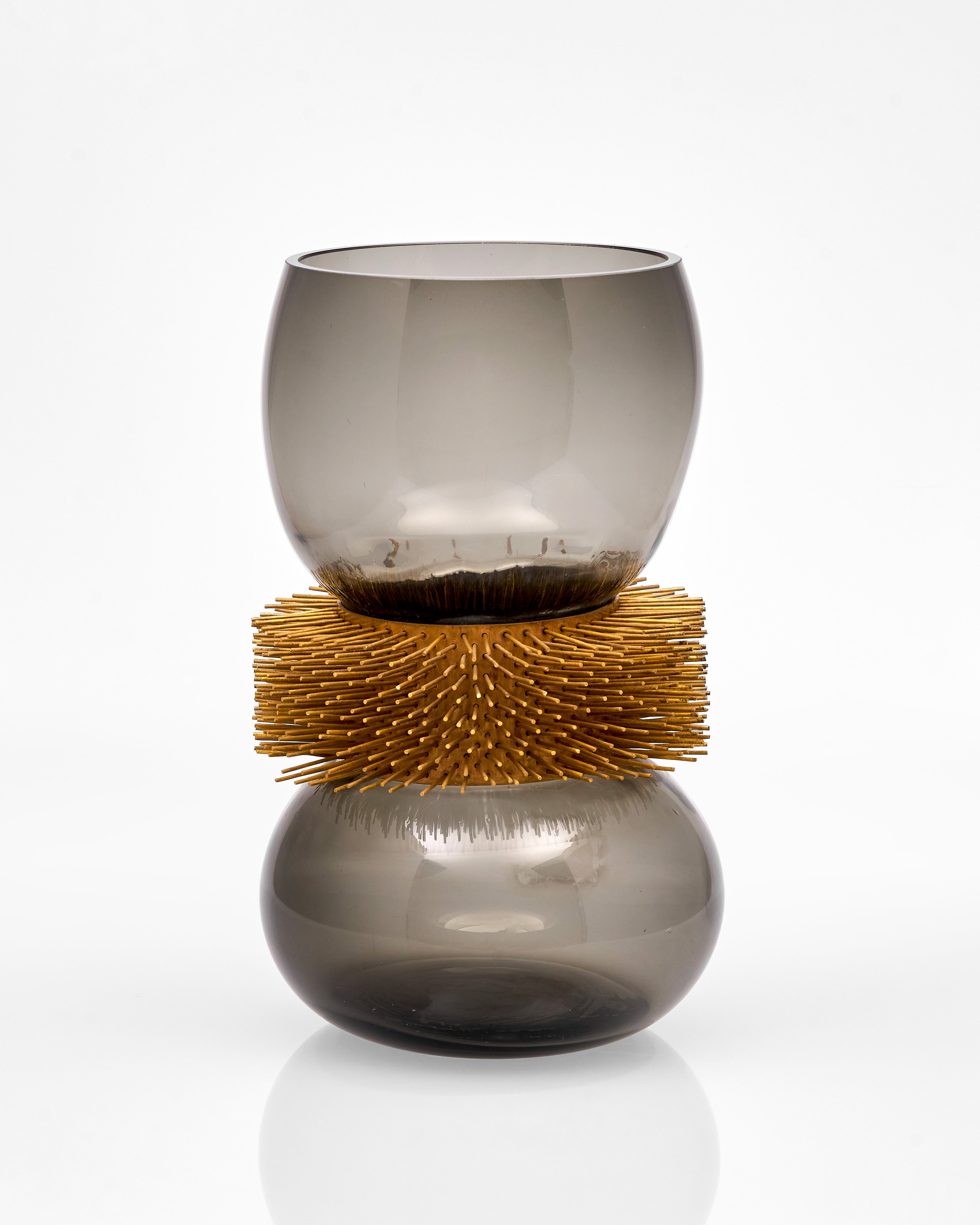 Decorative vase with smoked glass body and gold textured base on a white background
