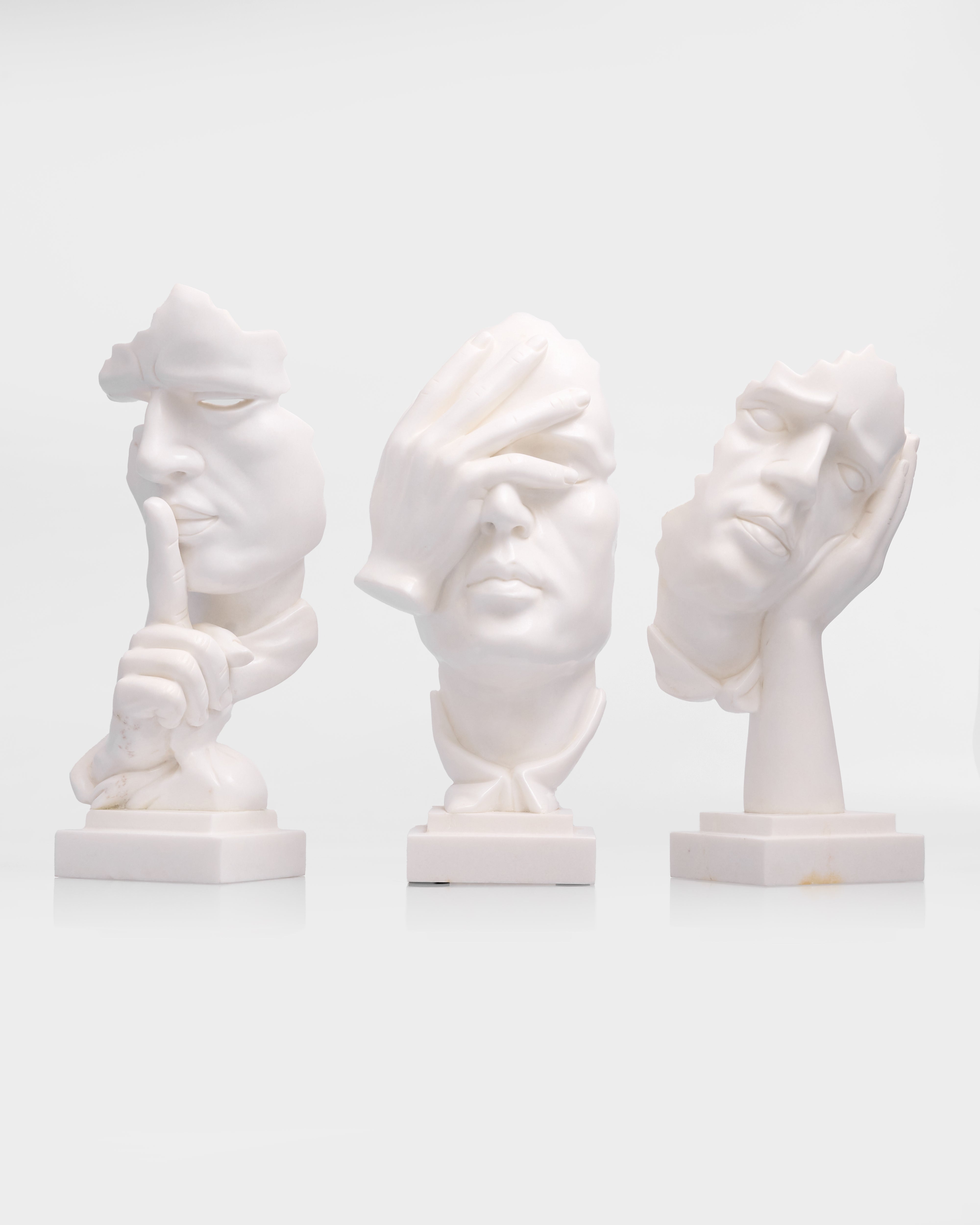 Three white marble busts on a white background
