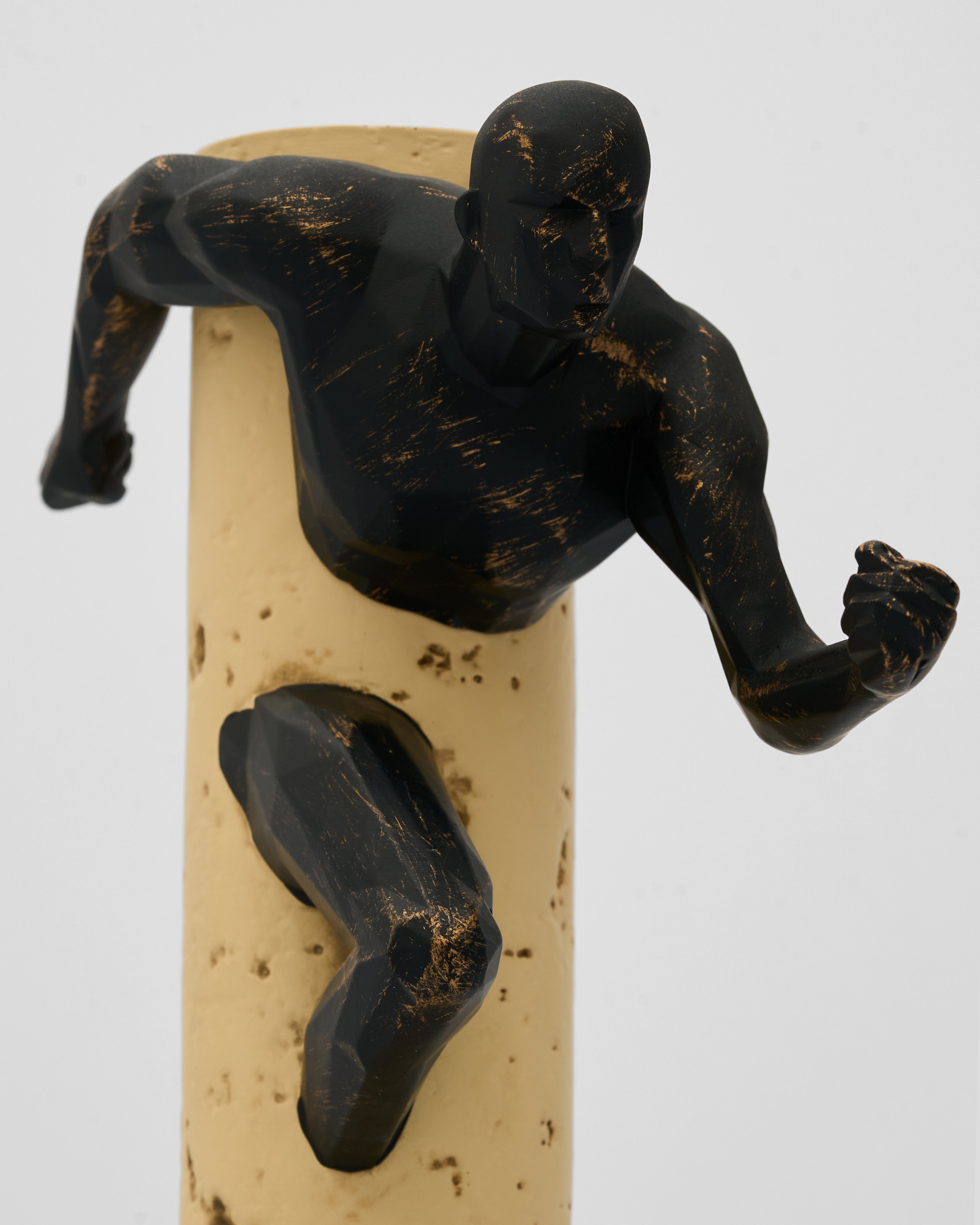 Black figurine on a beige cork against a white background