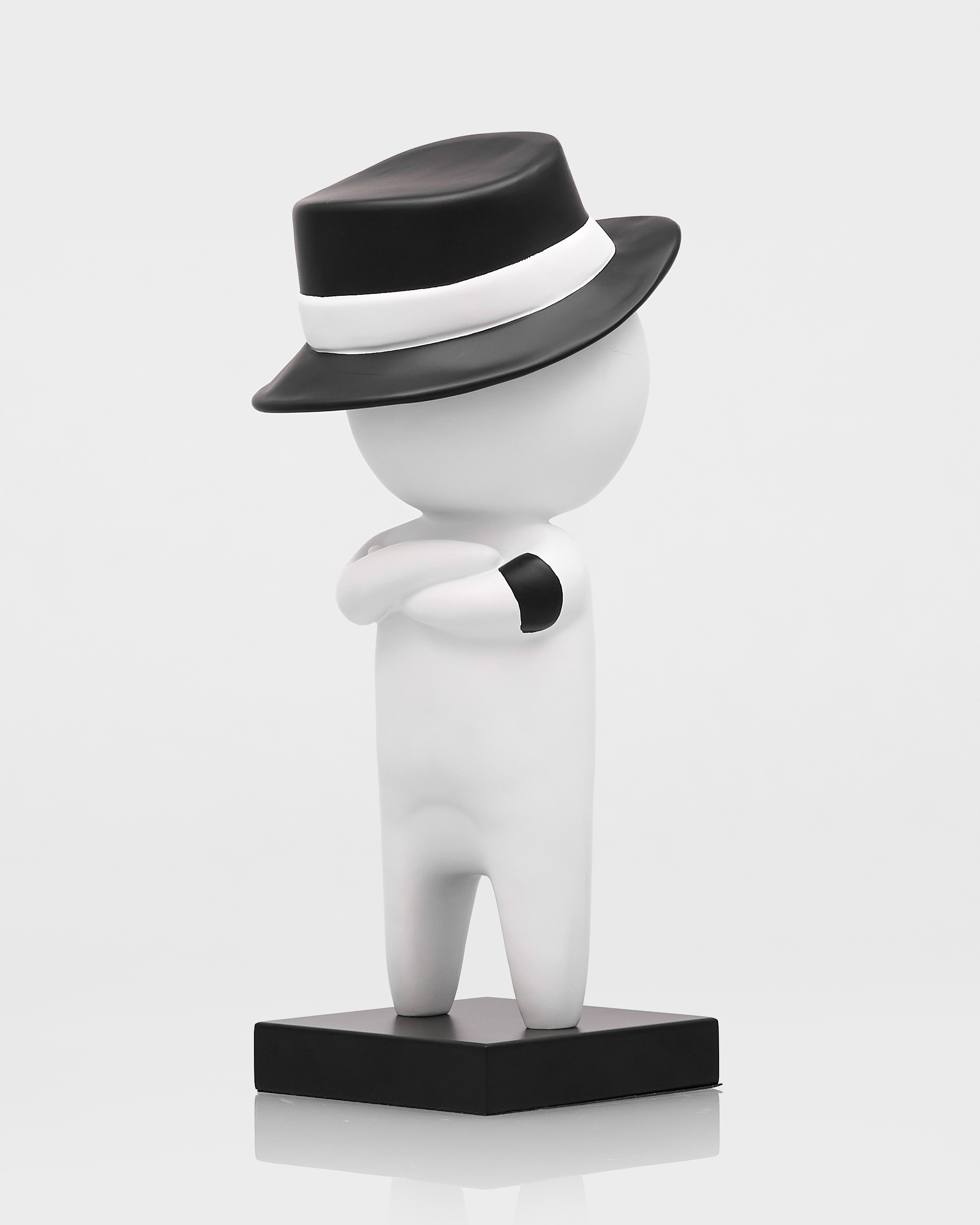 White figurine with a black hat on a white background