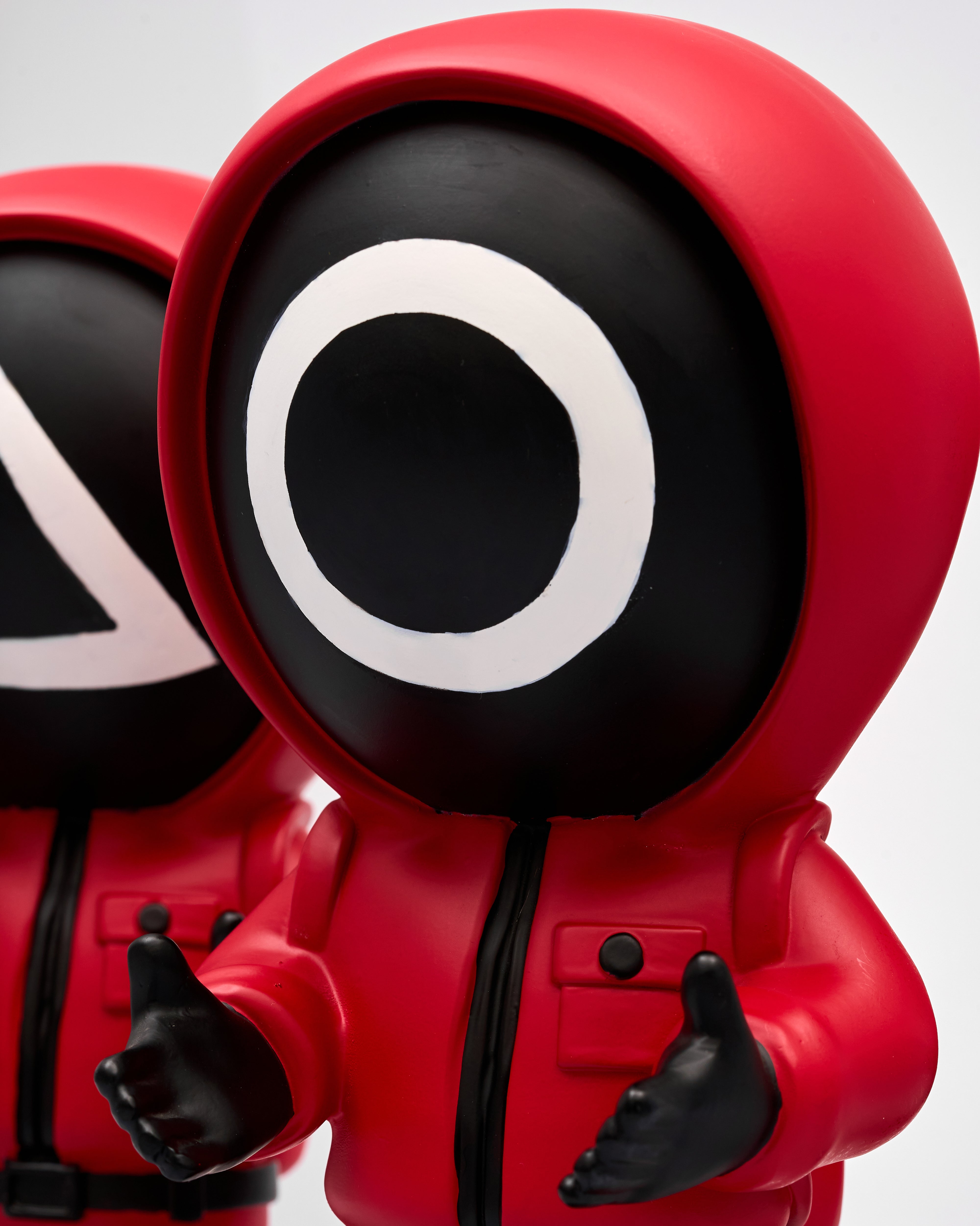 Red and black character figure with a distinctive circular design on a white background