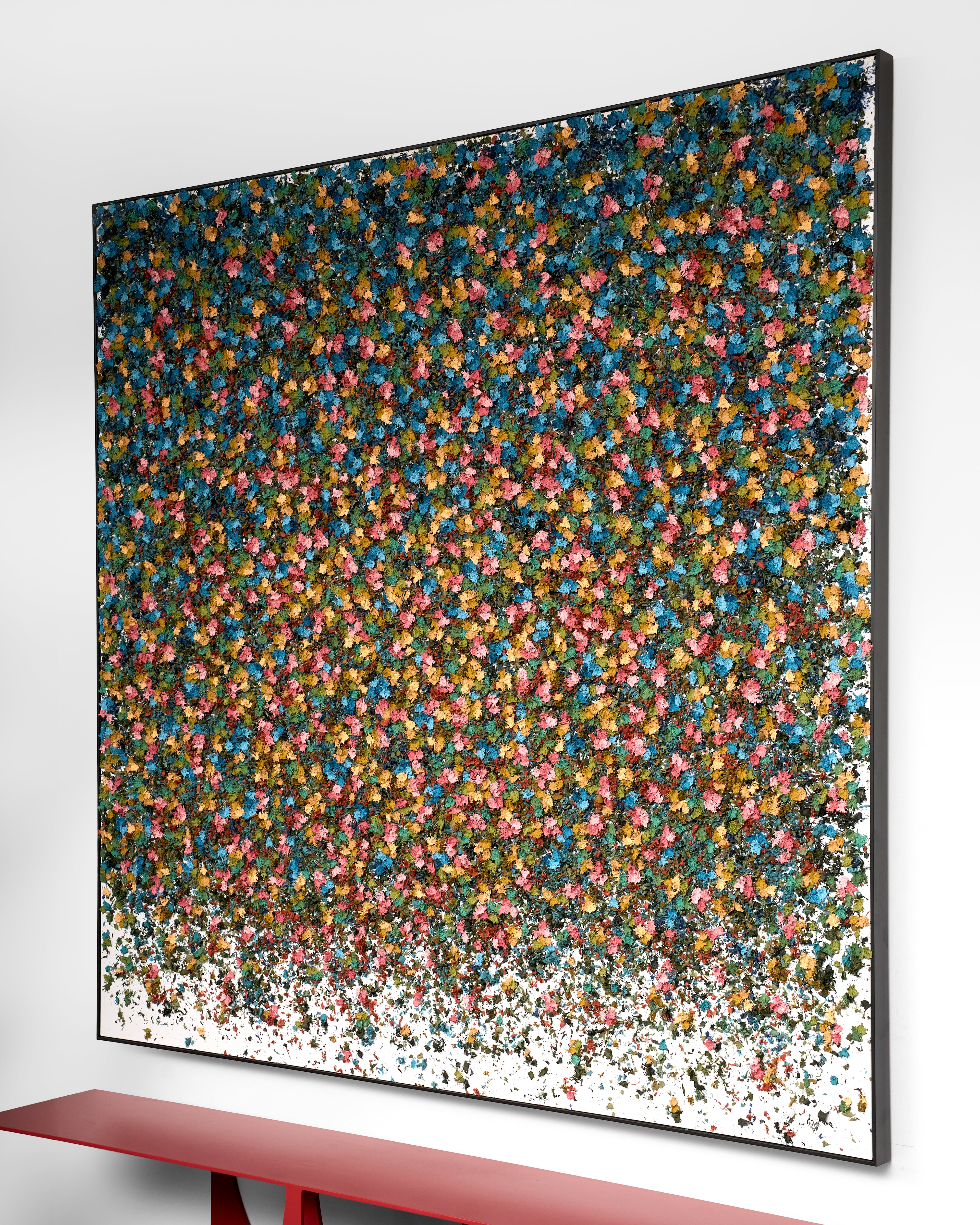 Abstract art piece with multicolored dots on a white wall
