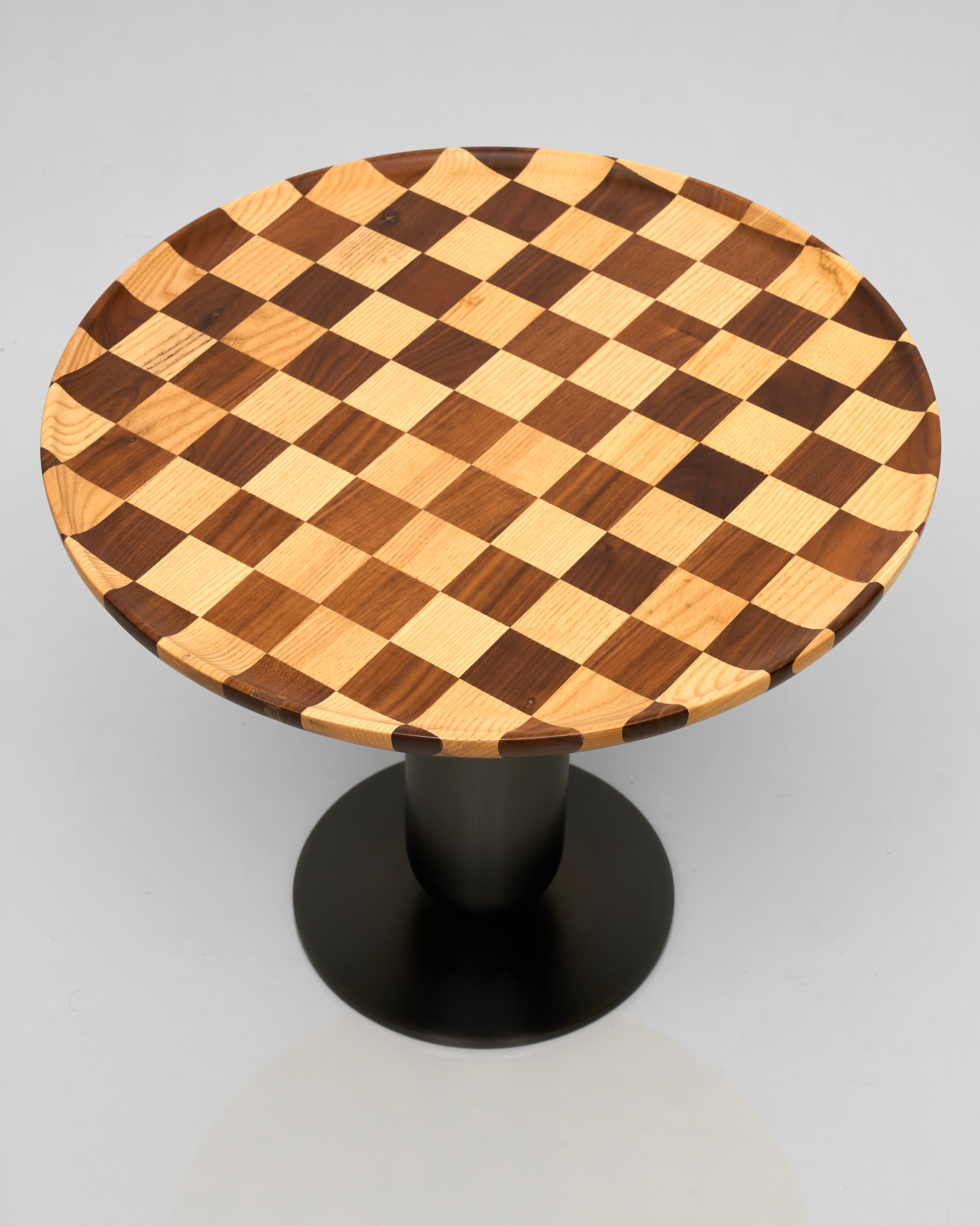 Round wooden table with a checkered pattern on a gray background