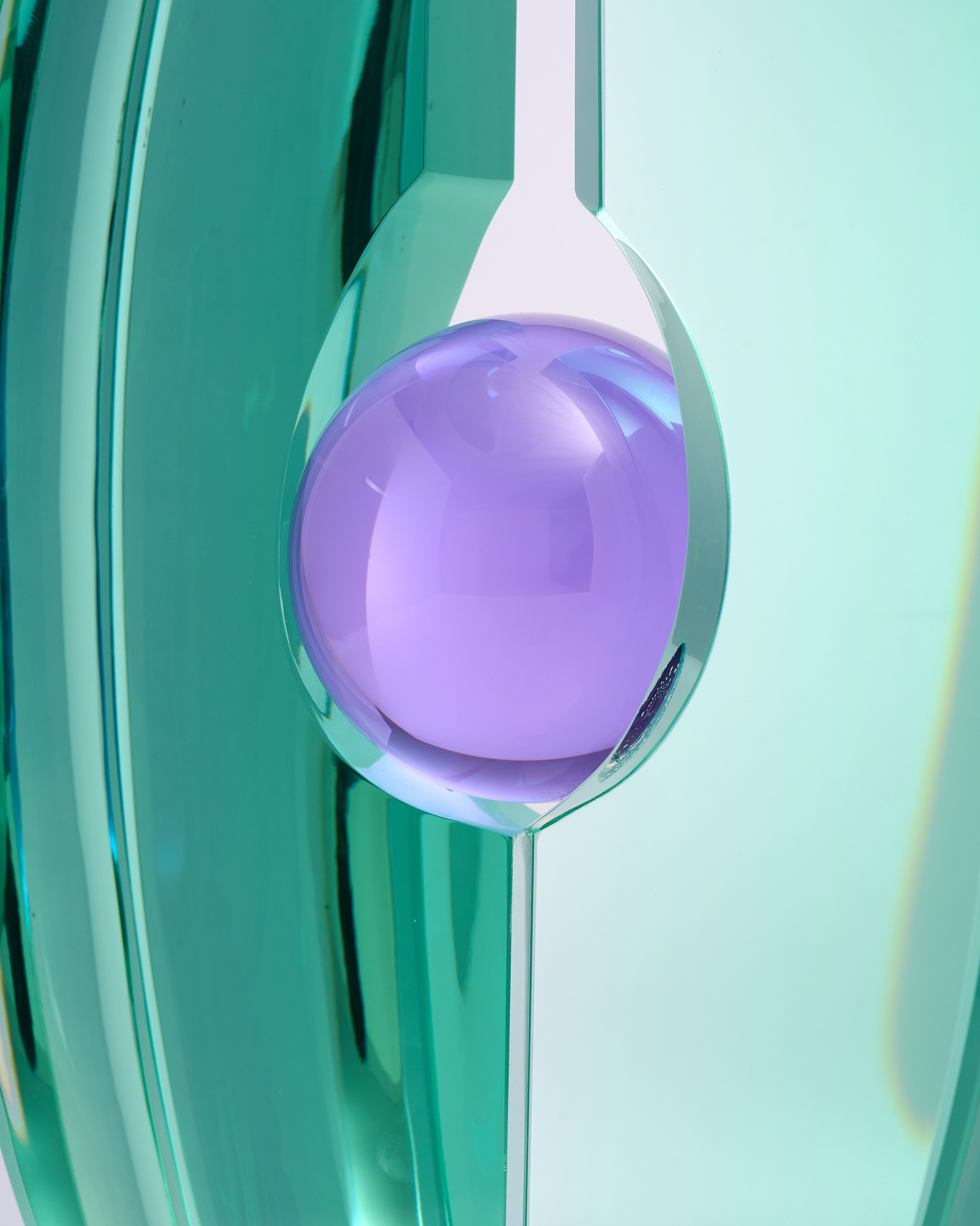 Close-up of a purple ball with a white handle against a teal background