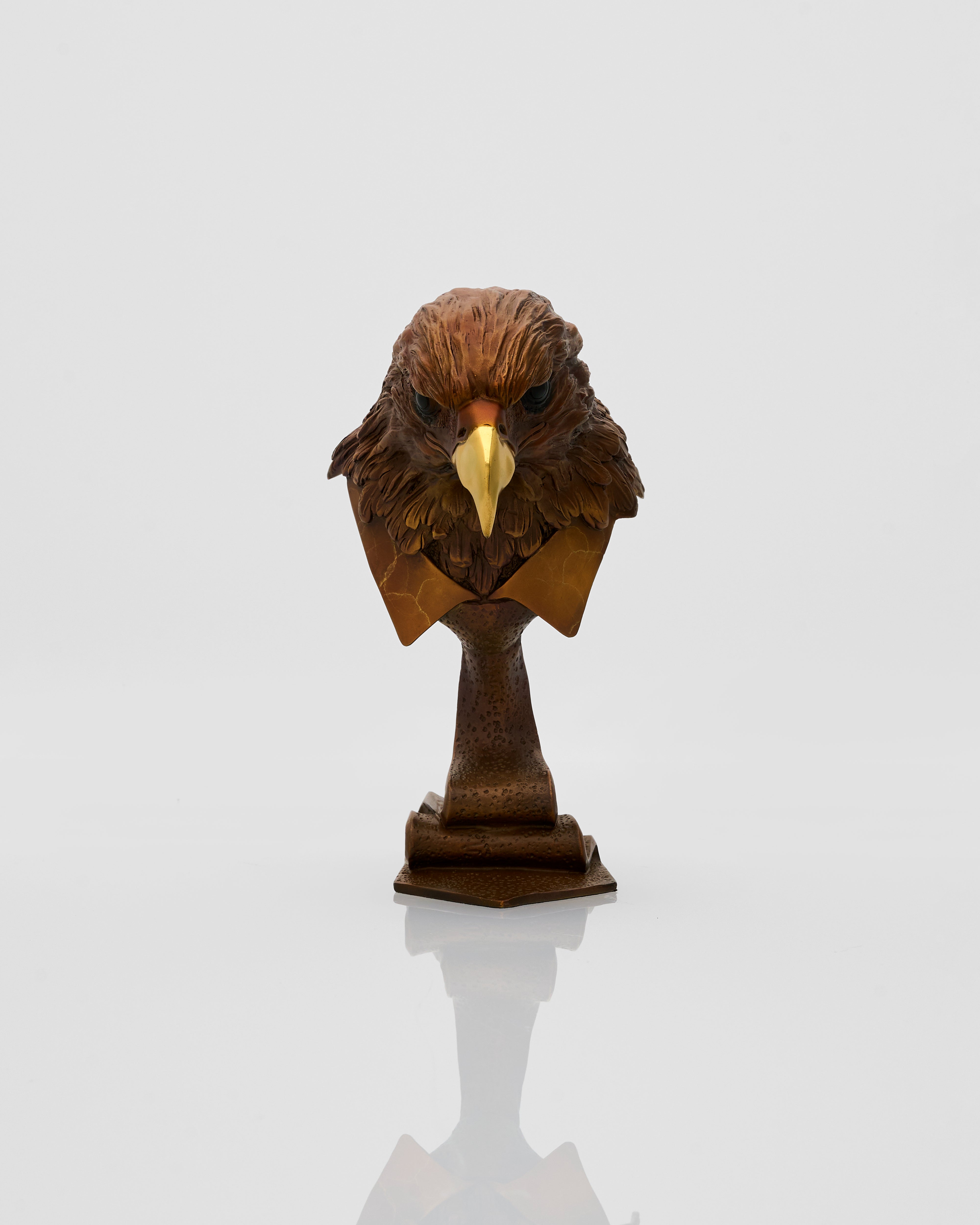 Bronze sculpture of an eagle head on a white background