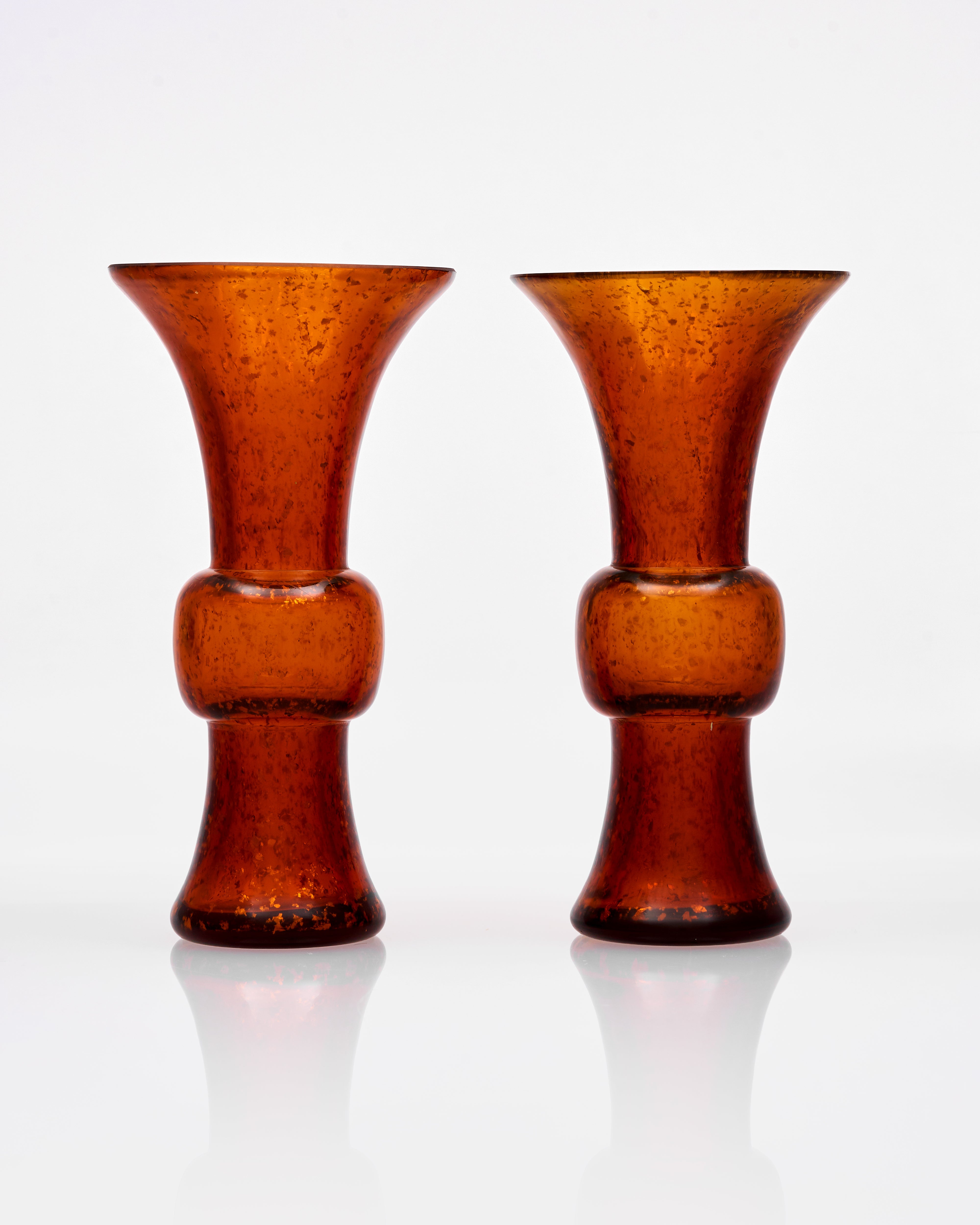 Two amber-colored glass vases on a white background