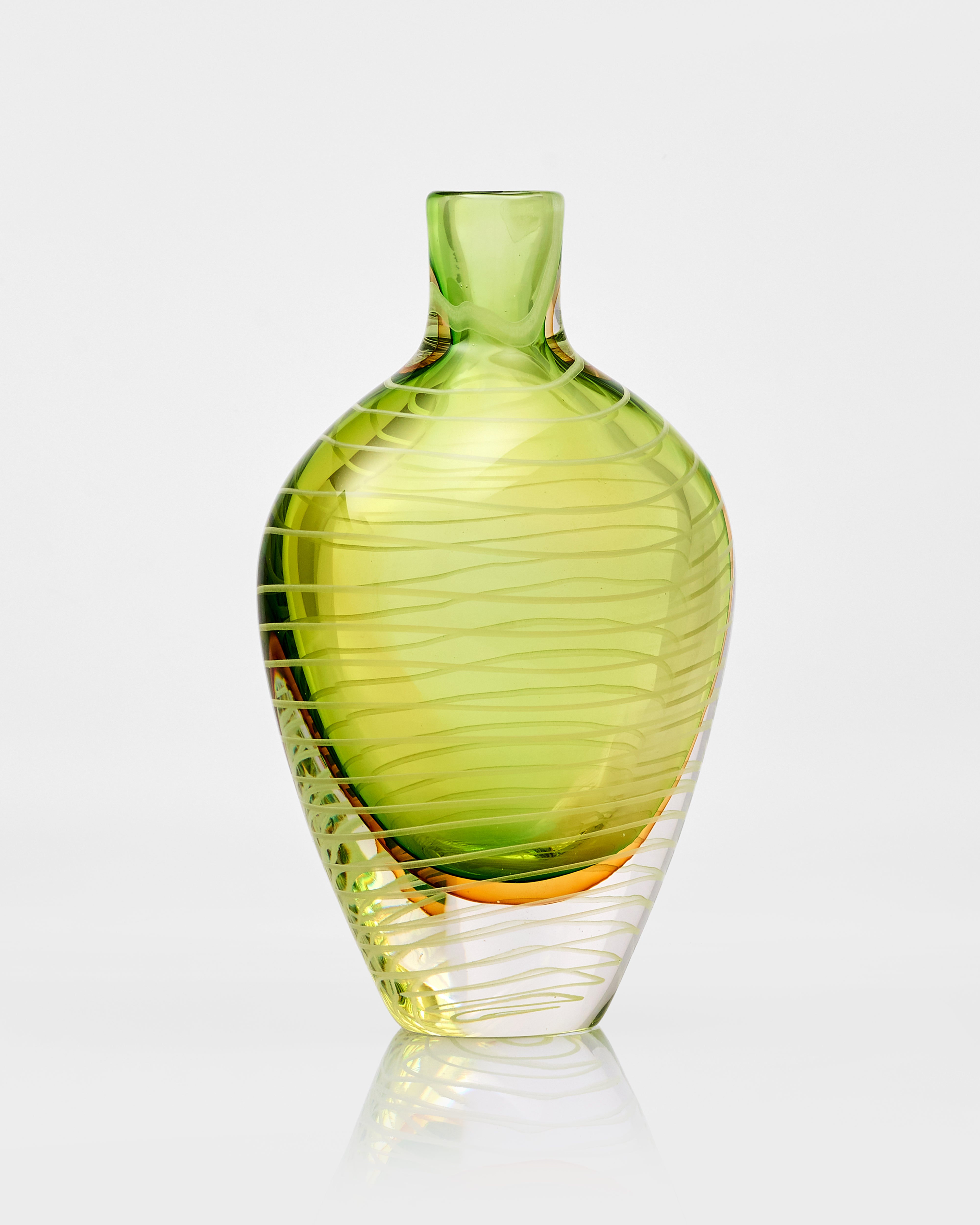 Green glass vase with ribbed texture on a white background