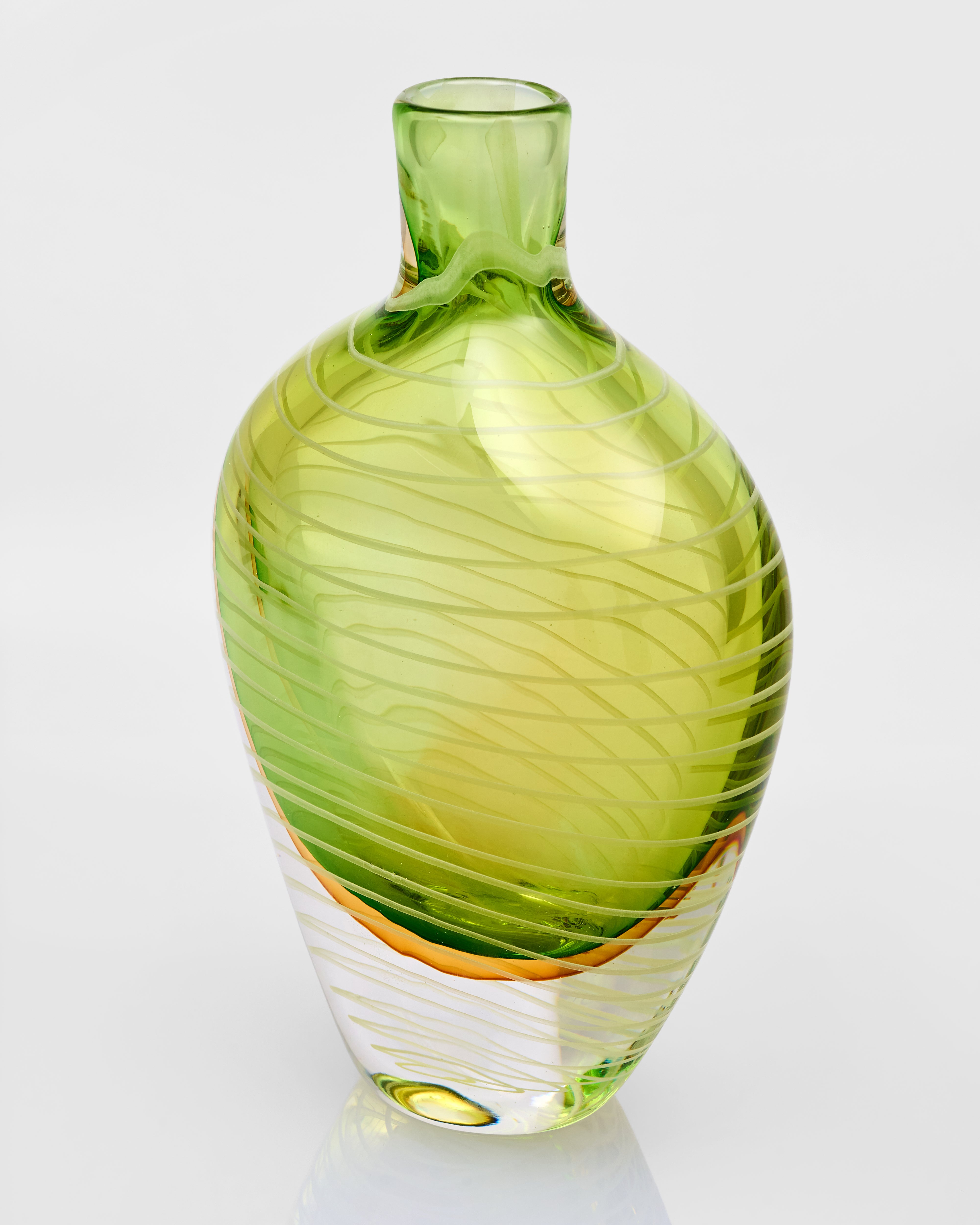 Green glass vase with swirling pattern on a white background