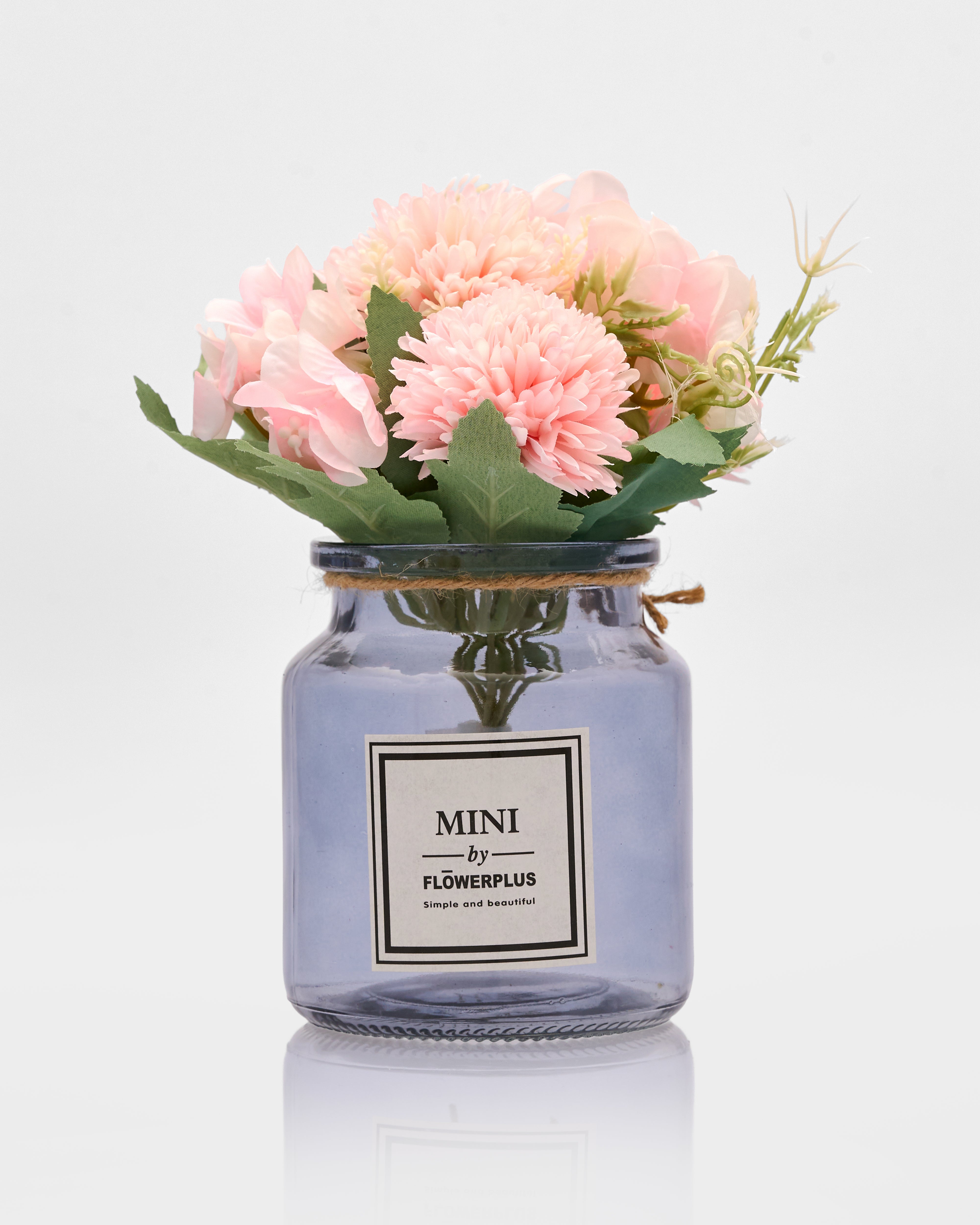 Glass jar with pink flowers and a visible brand label on a white background