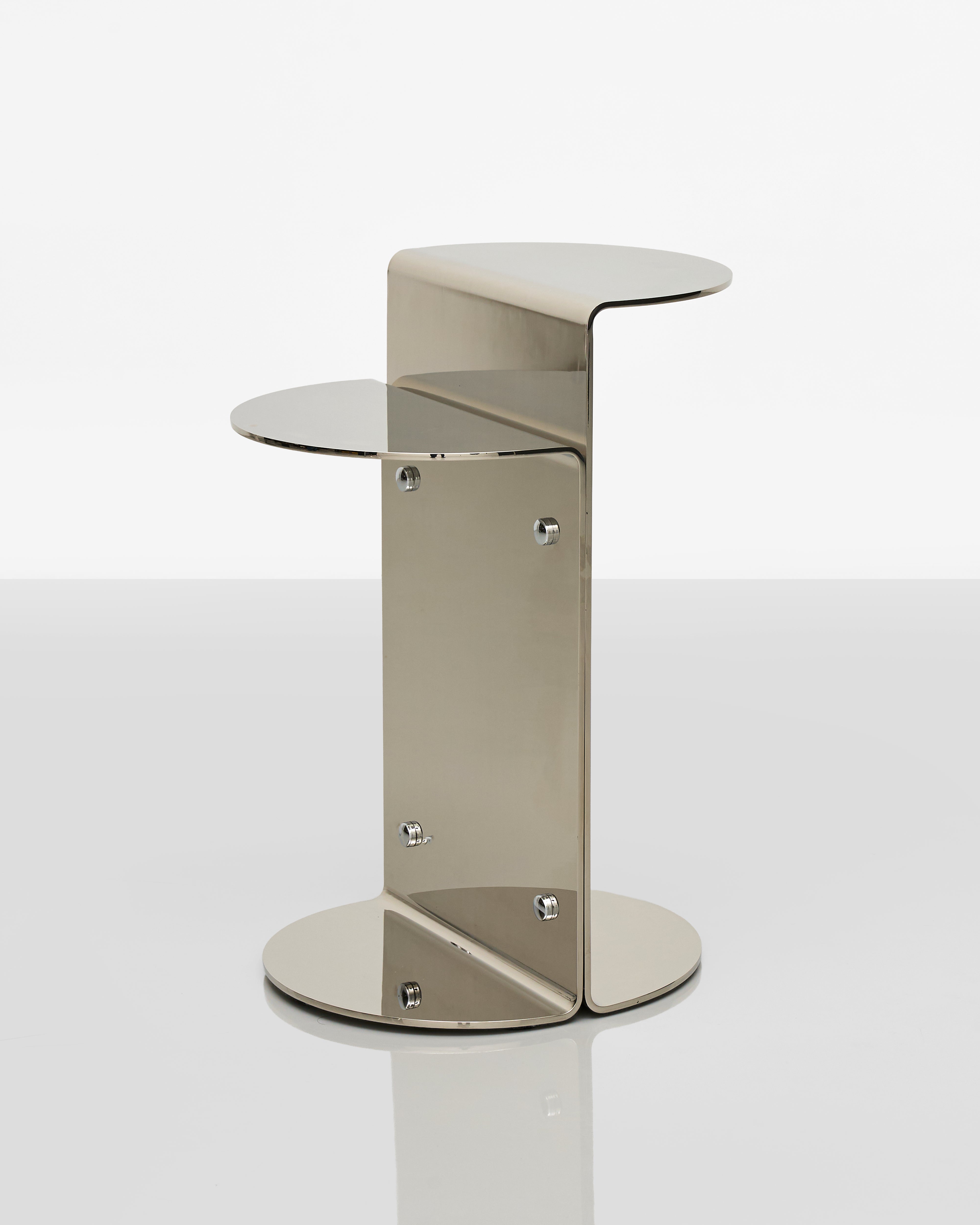 Modern side table with a metallic finish on a white background