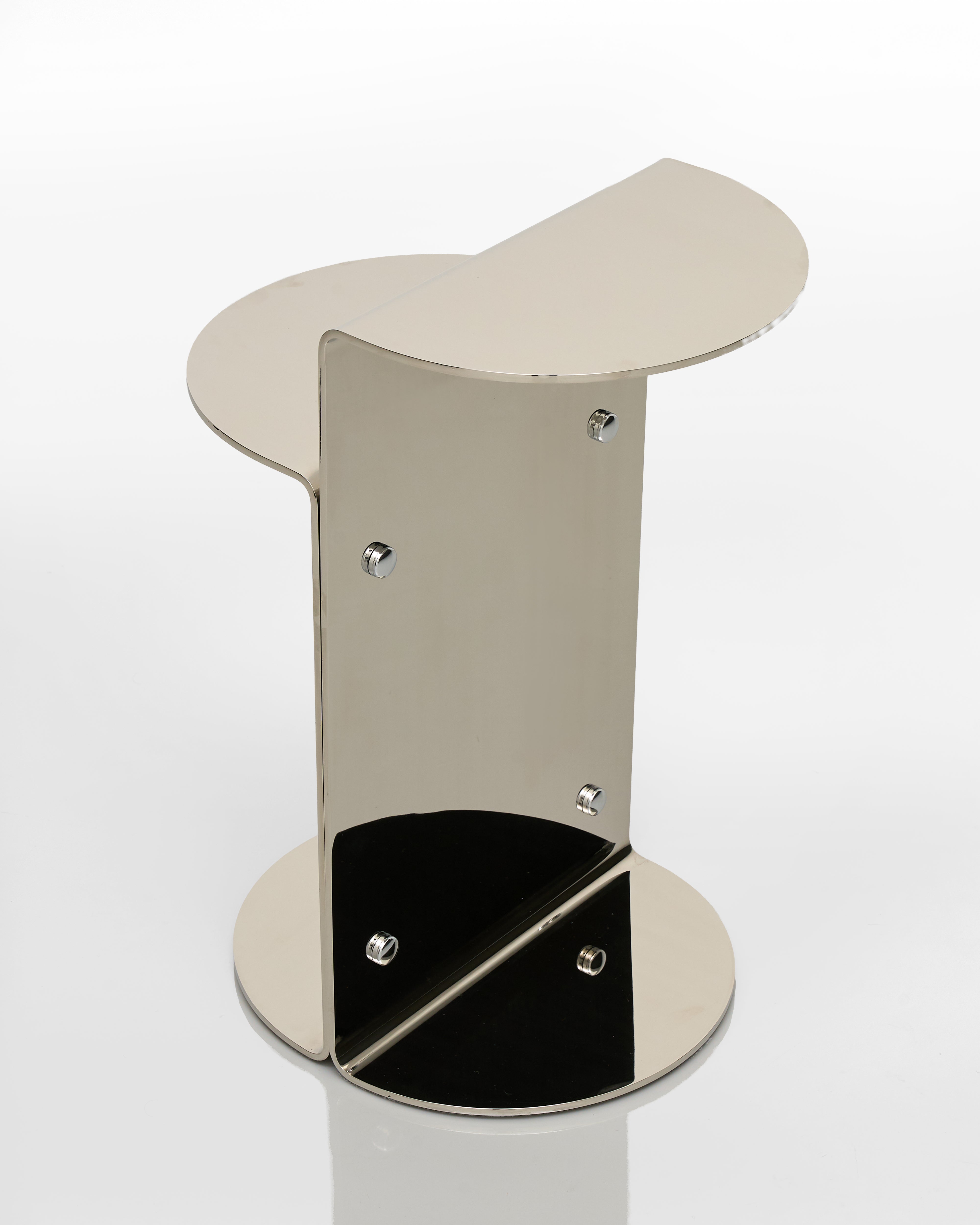 Metallic stand side table with a curved top on a white background