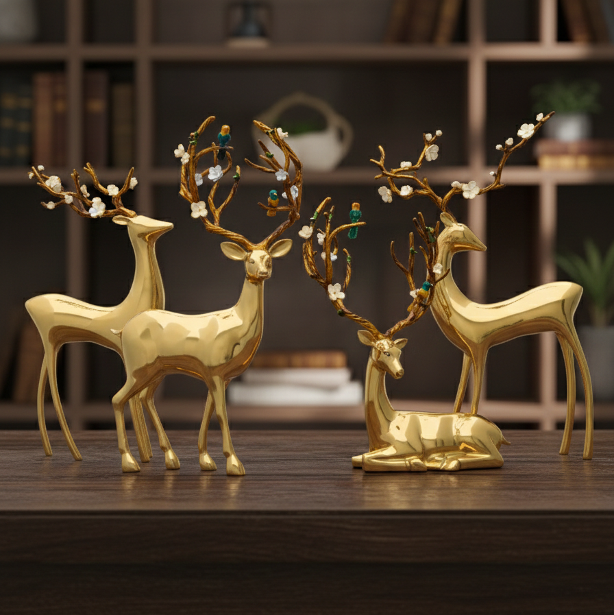 Gold deer figurines with decorative antlers on a wooden surface