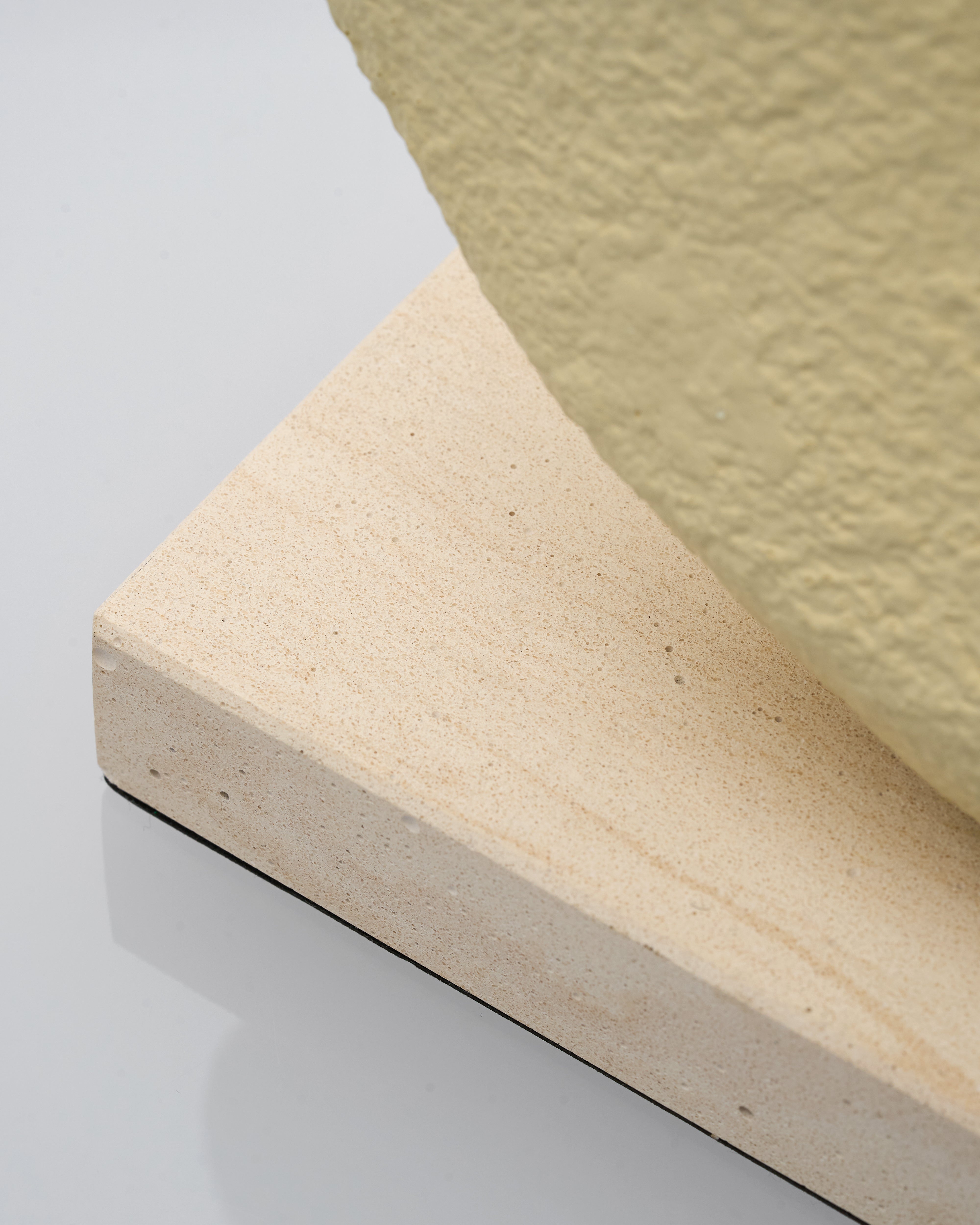 Close-up of a mattress corner with a textured surface on a light gray background