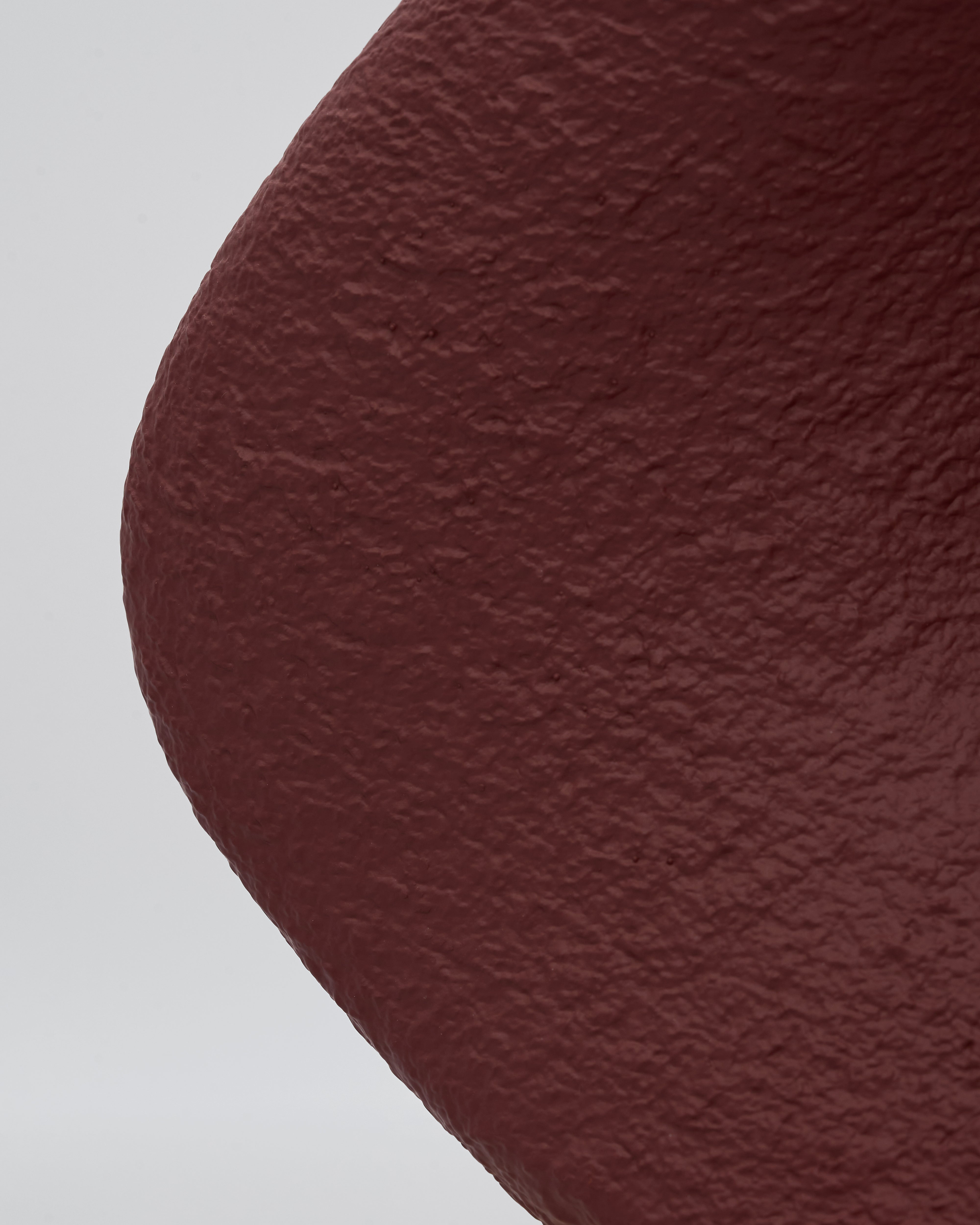 Close-up of a textured brown circle on a light gray background