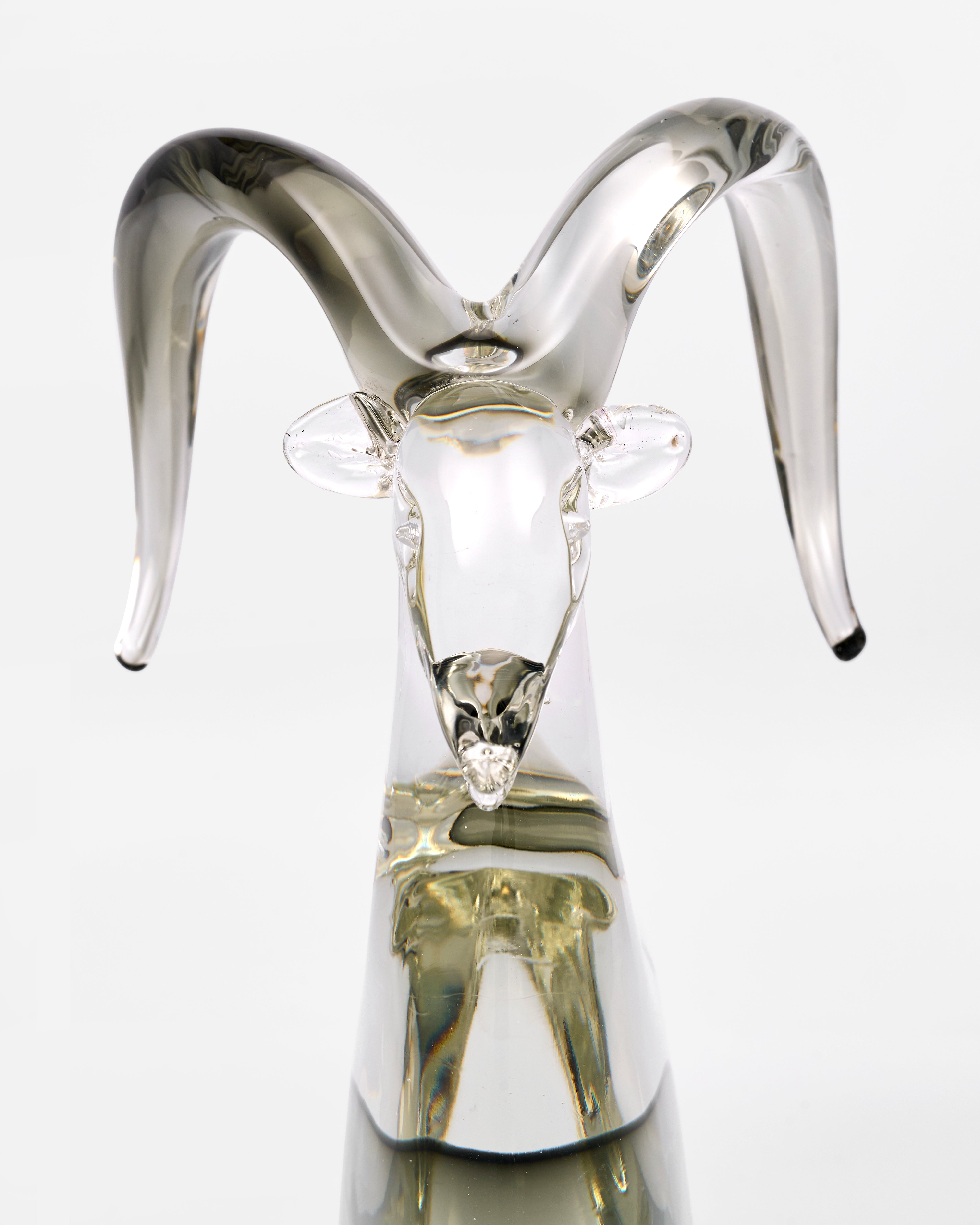 Glass sculpture of a goat with silver horns on a white background