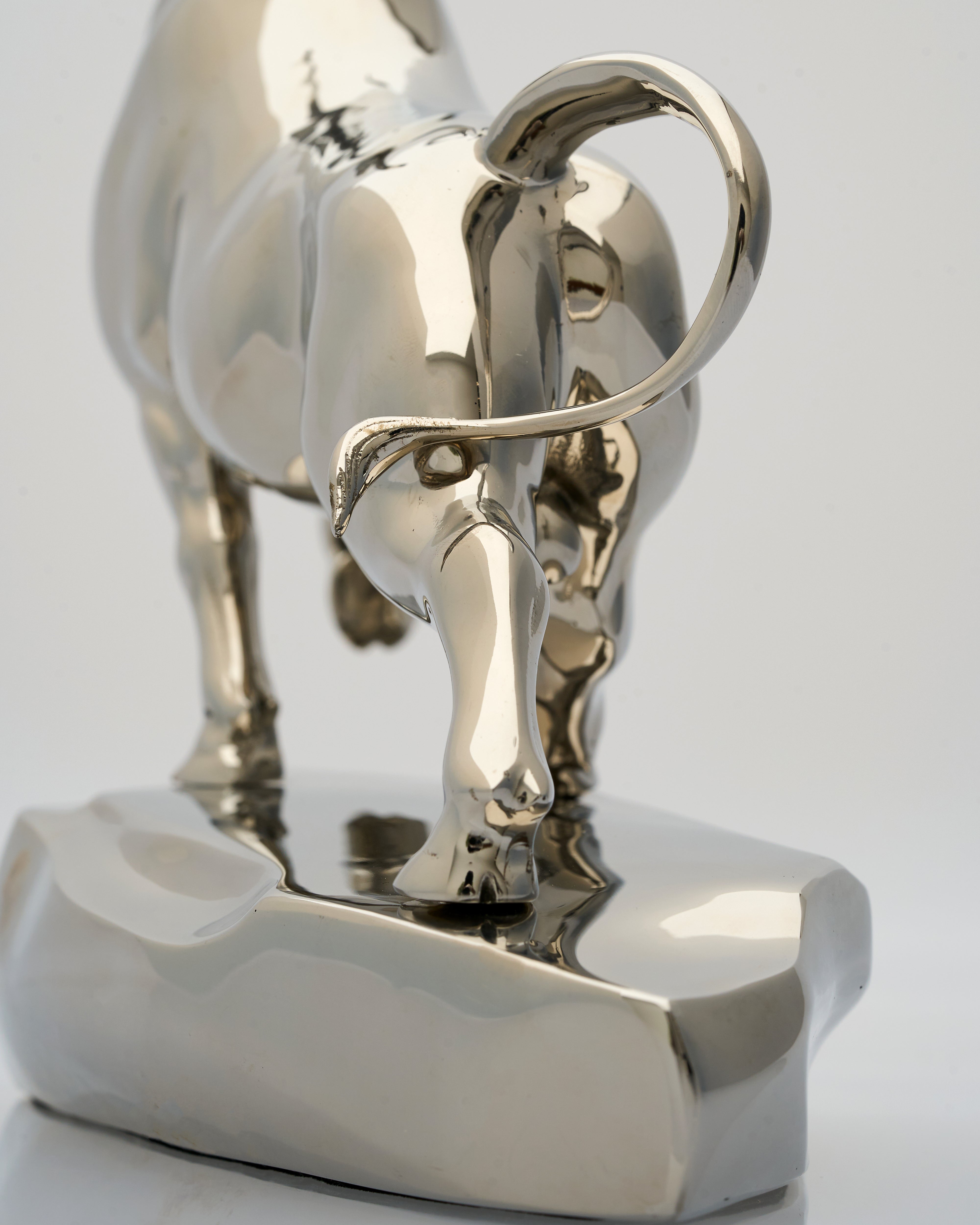 Metallic bull sculpture on a white background