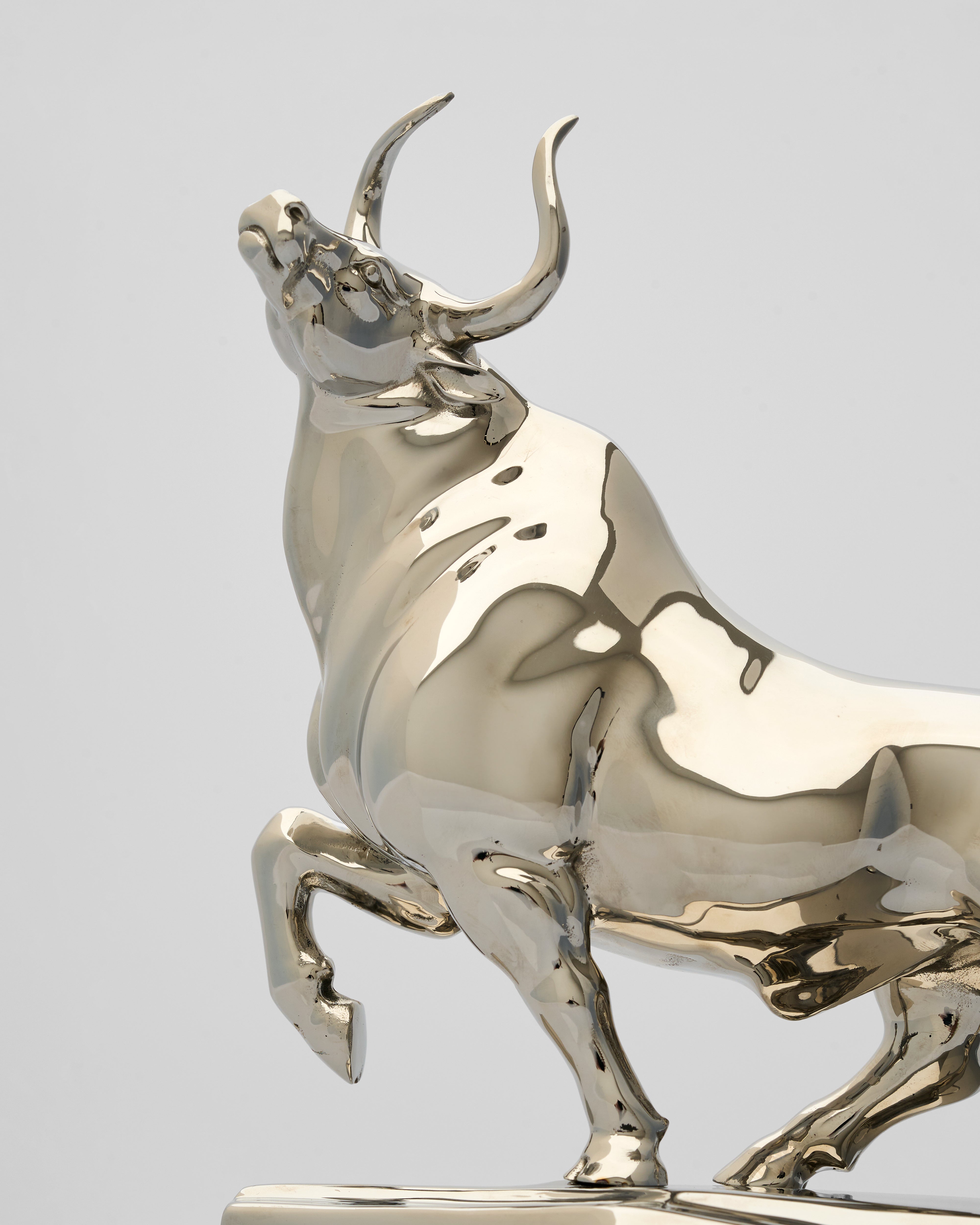 Metallic bull statue on a light gray background
