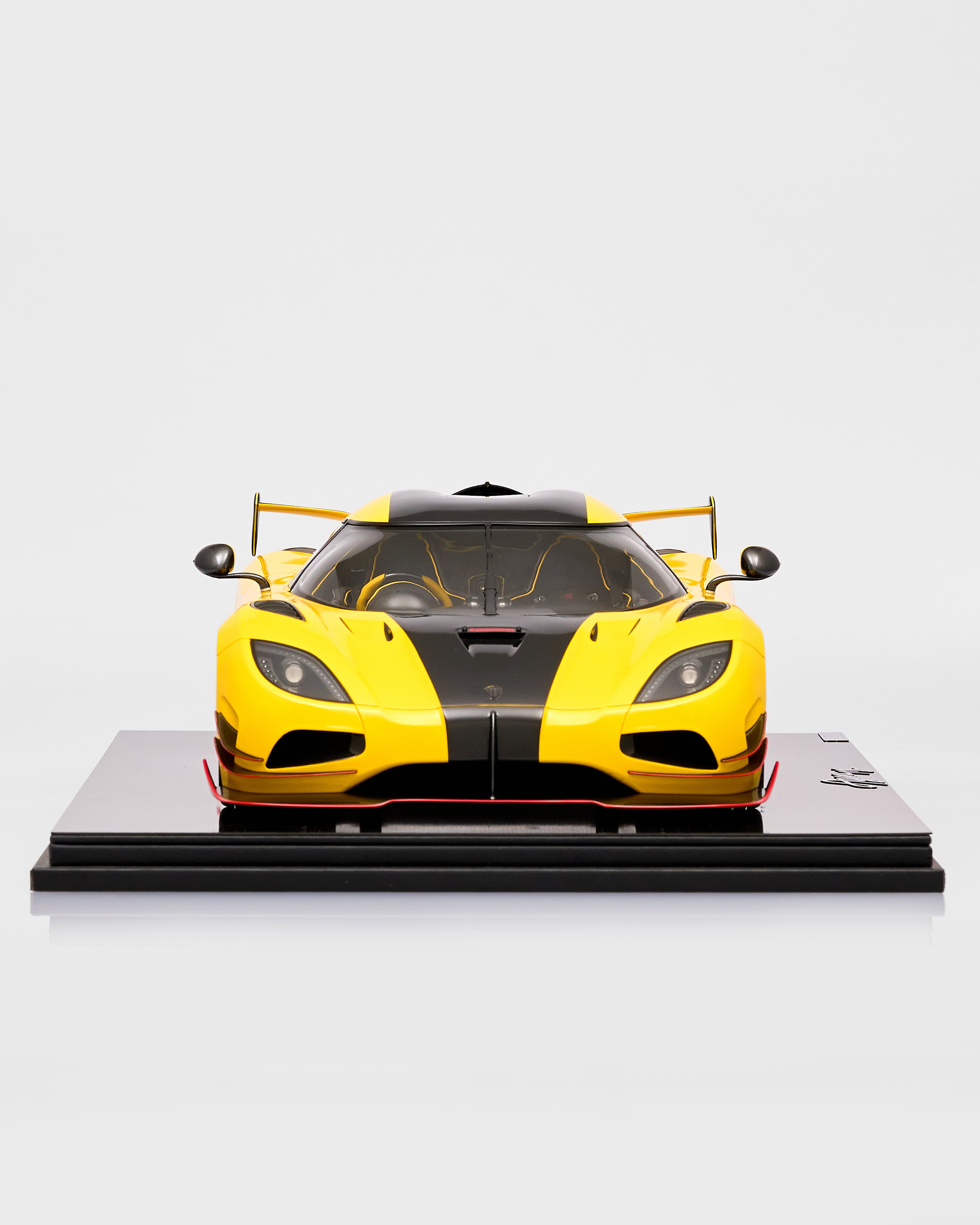 Yellow and black sports car model on a white background