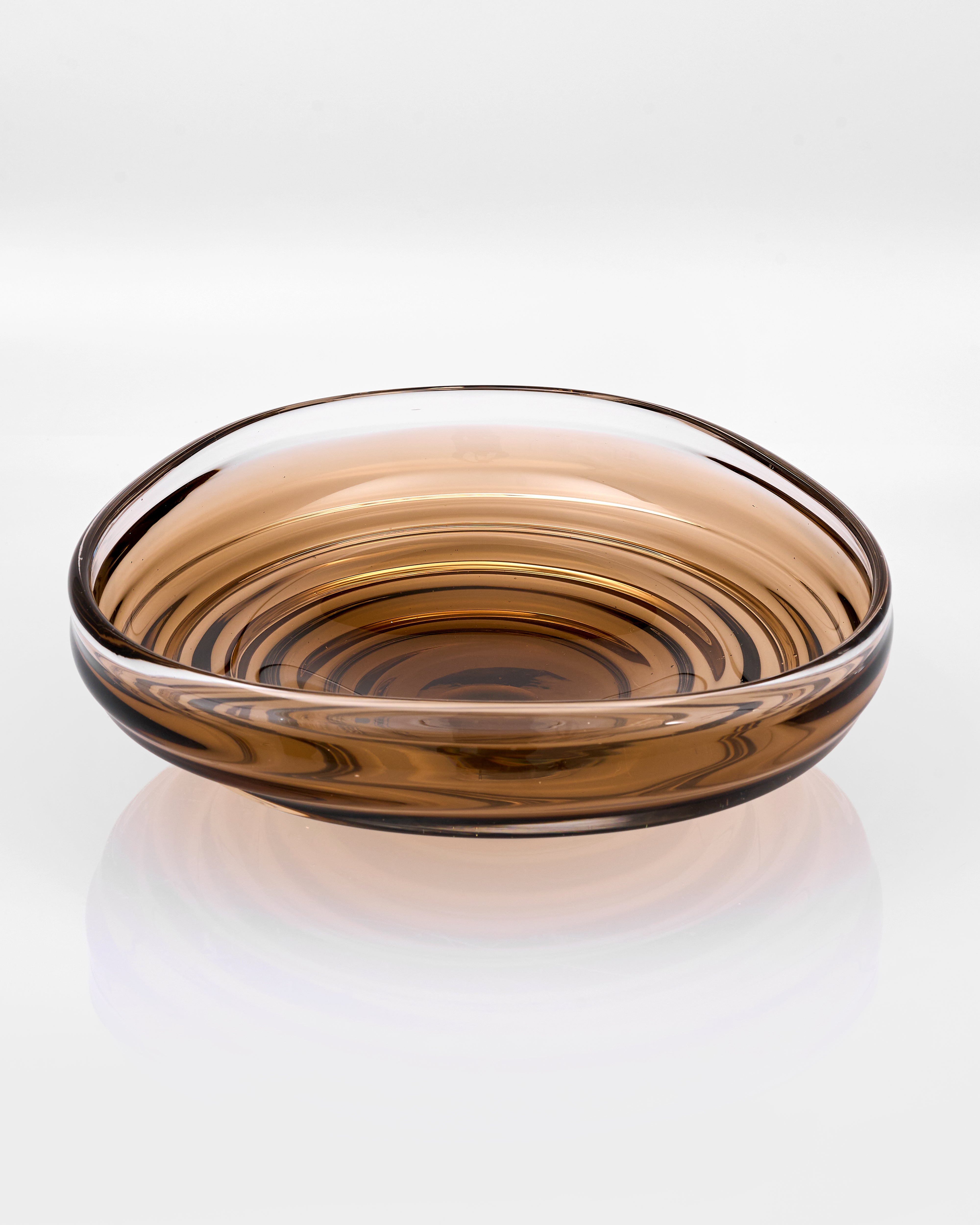 Glass bowl with brown and clear swirl pattern on a white background