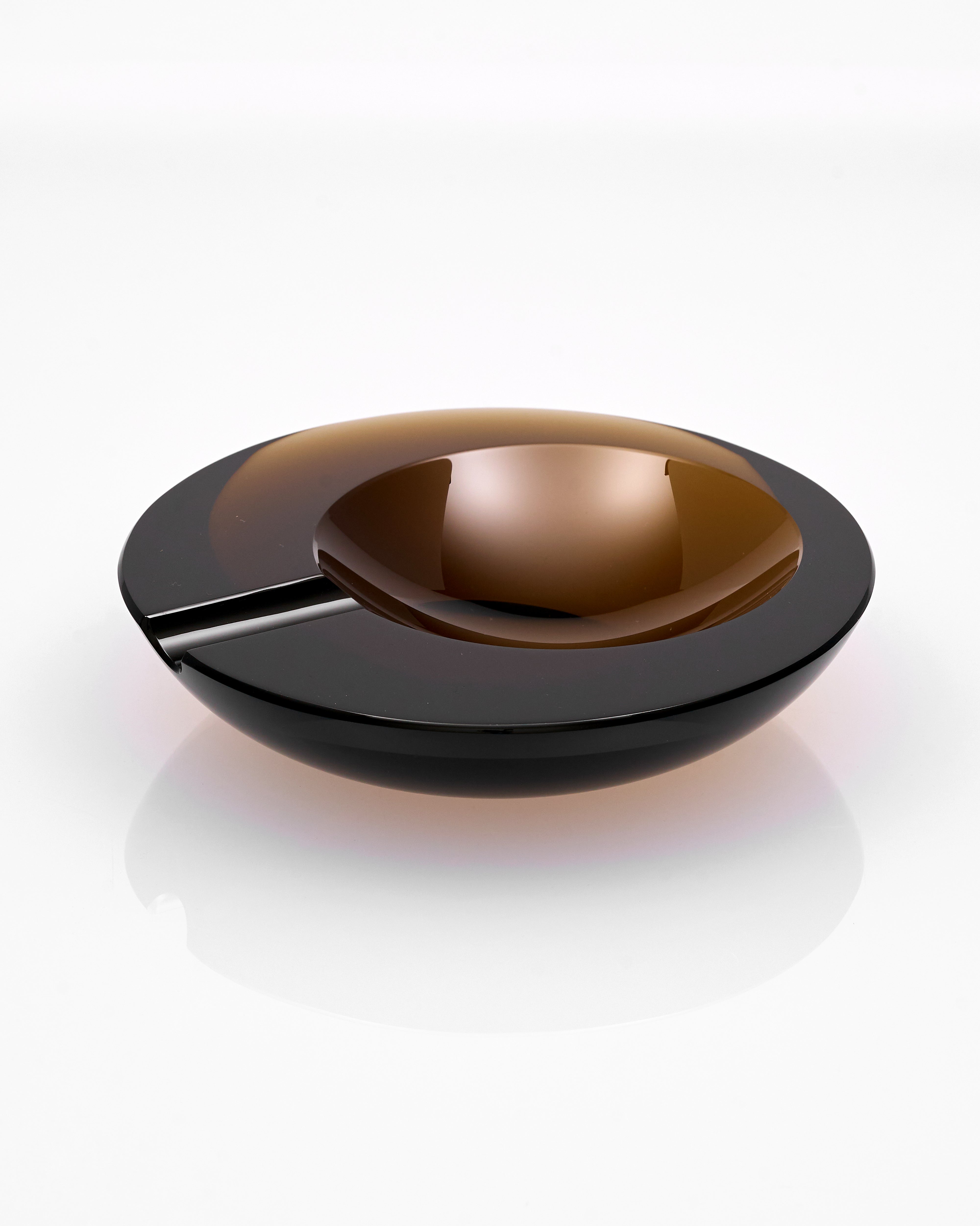 Black glass ash tray on a white background tray
