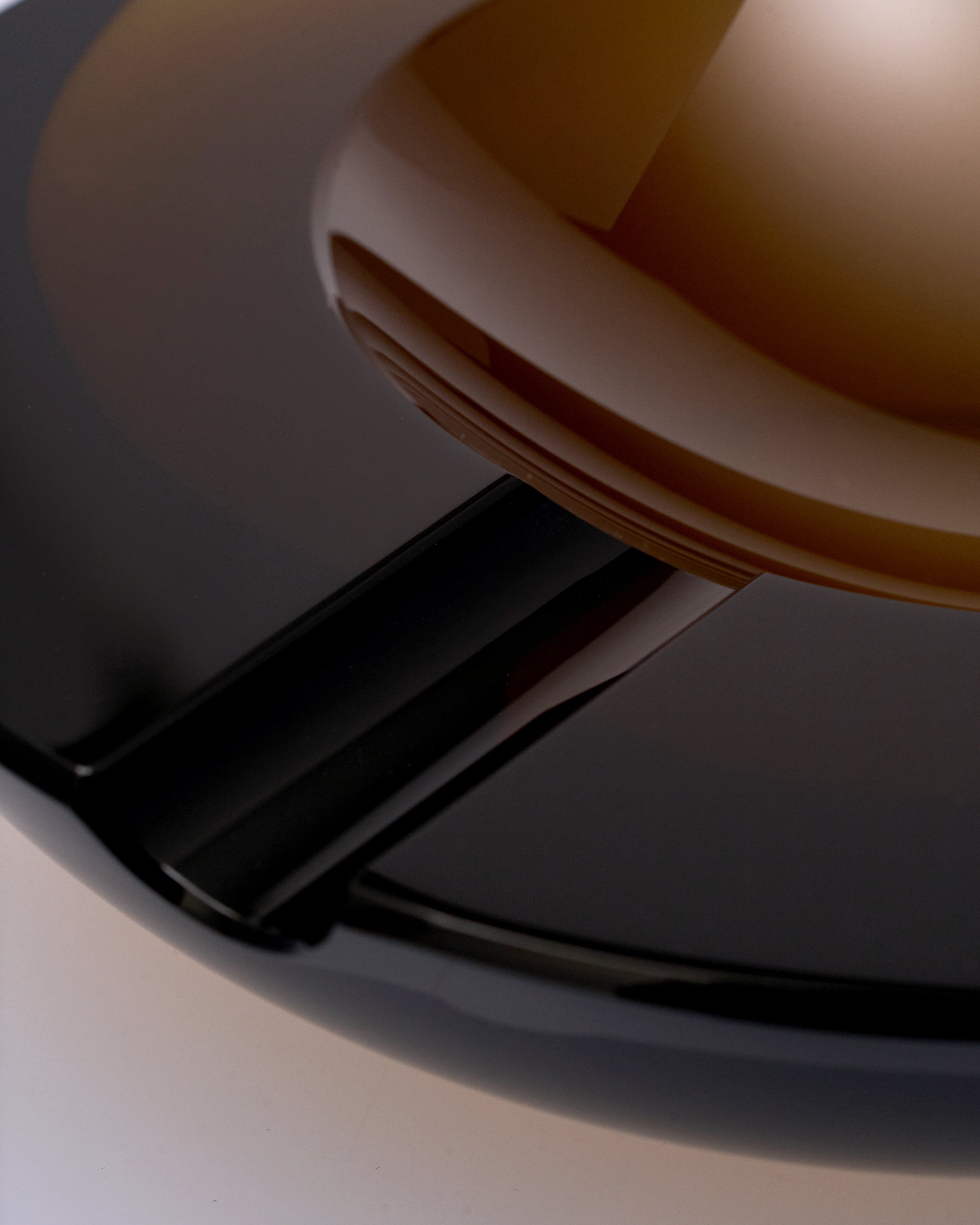 Close-up of a brown crystal glass ashtray on a neutral background