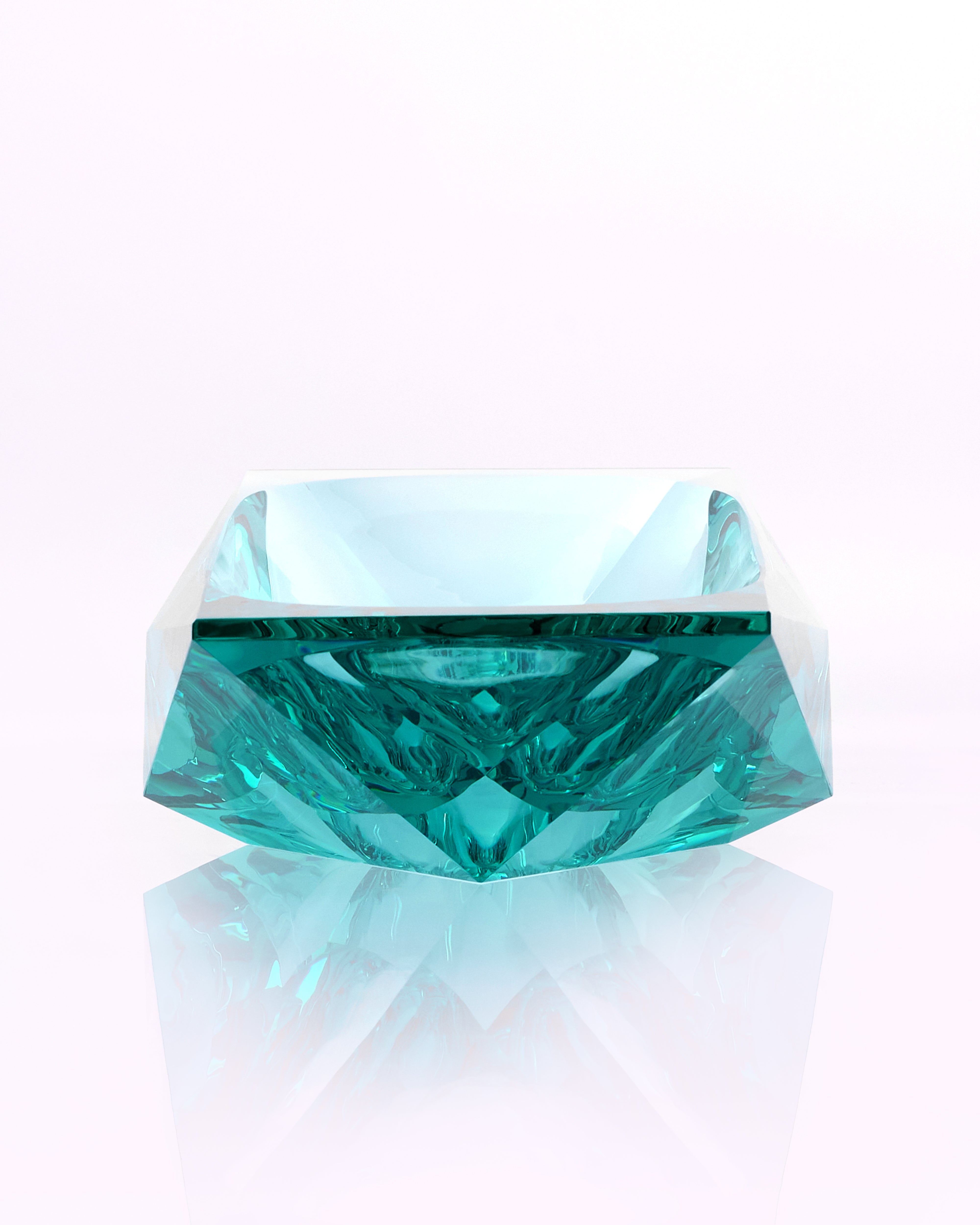 Teal crystal on a reflective white surface