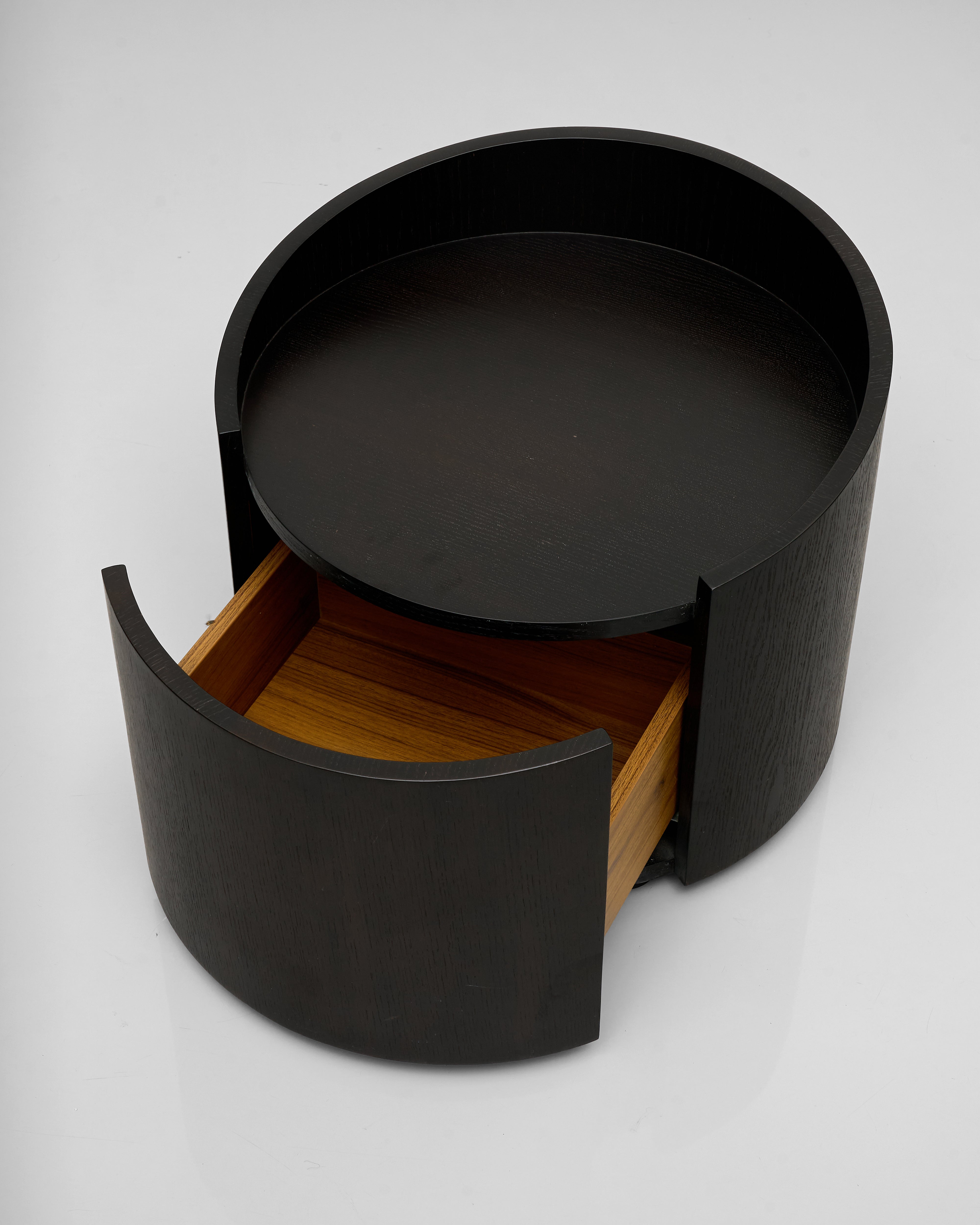 Black cylindrical side table with a wooden interior on a white background