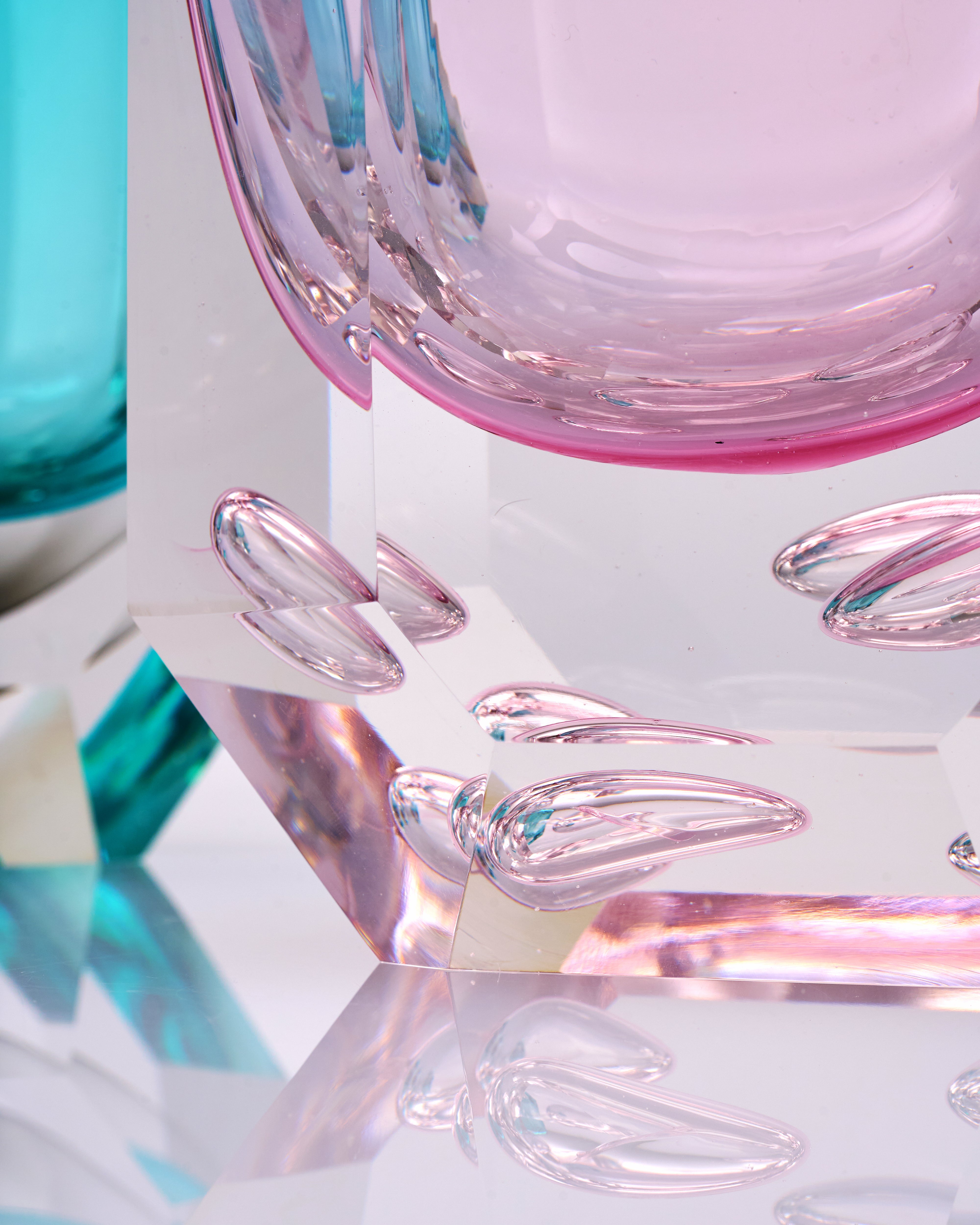 Close-up of a pink and clear glass object with a blurred background
