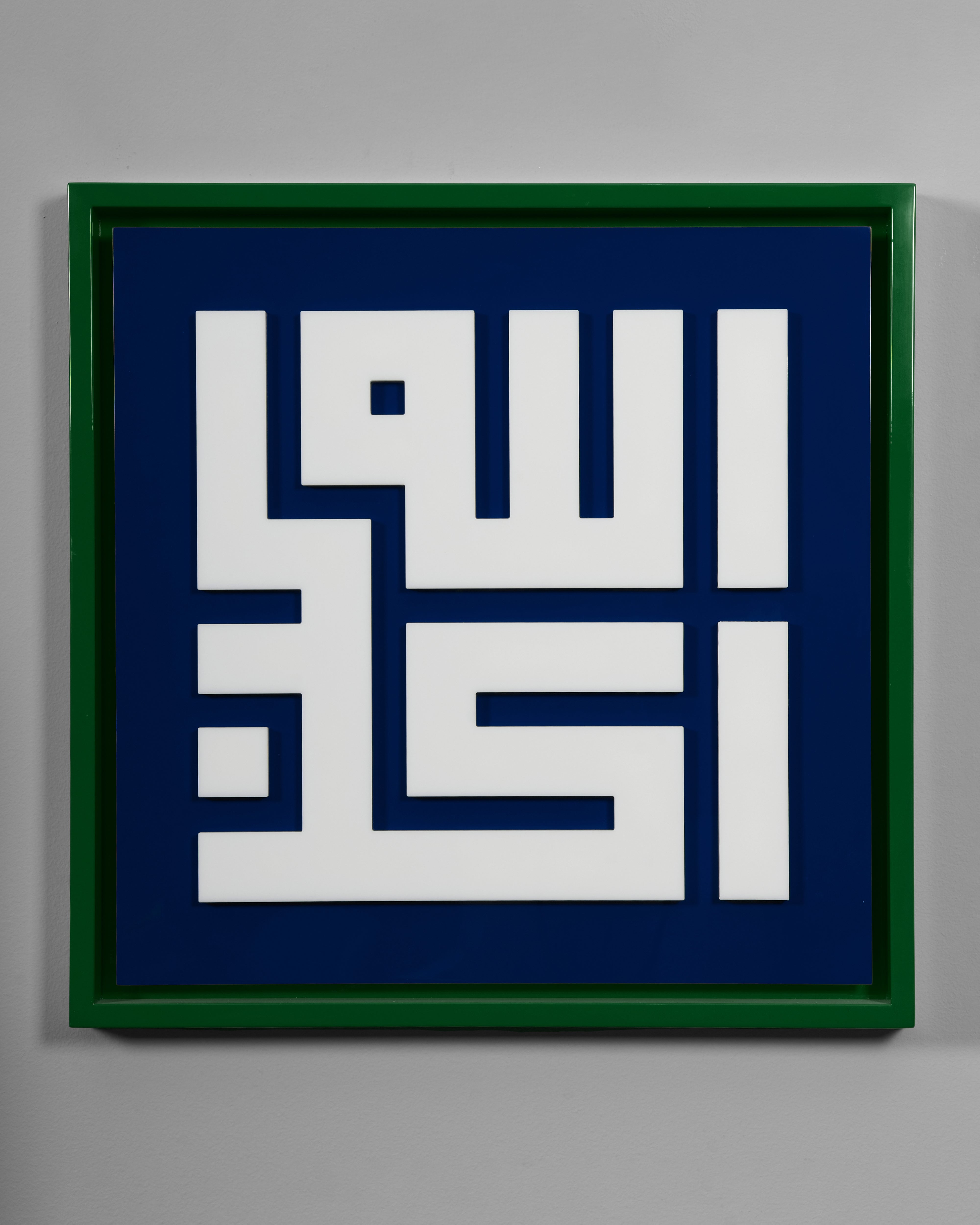 Framed artwork with white Arabic calligraphy on a blue background