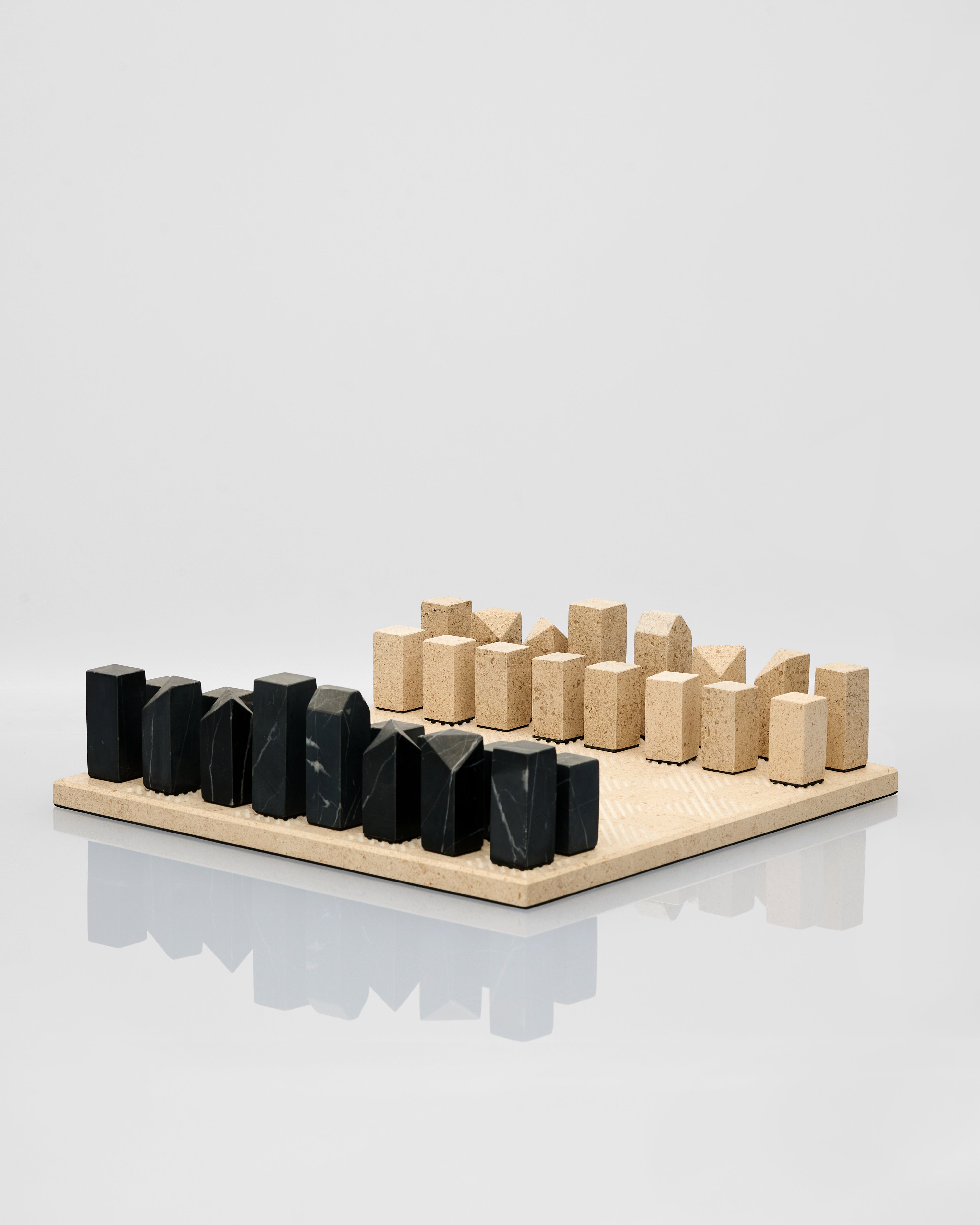 marble and black stone chess pieces on a light gray background