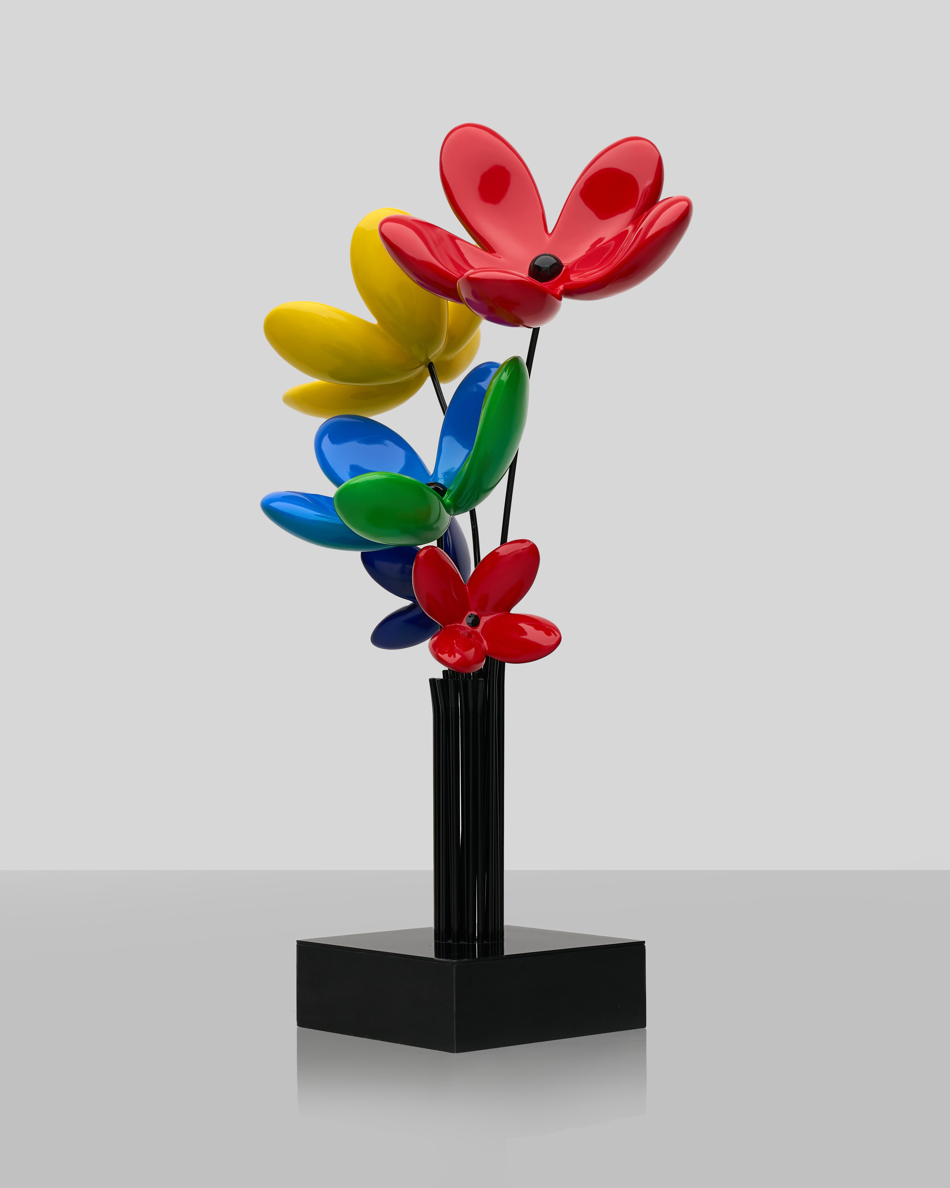 Colorful flower-shaped objects on a black stand against a light gray background