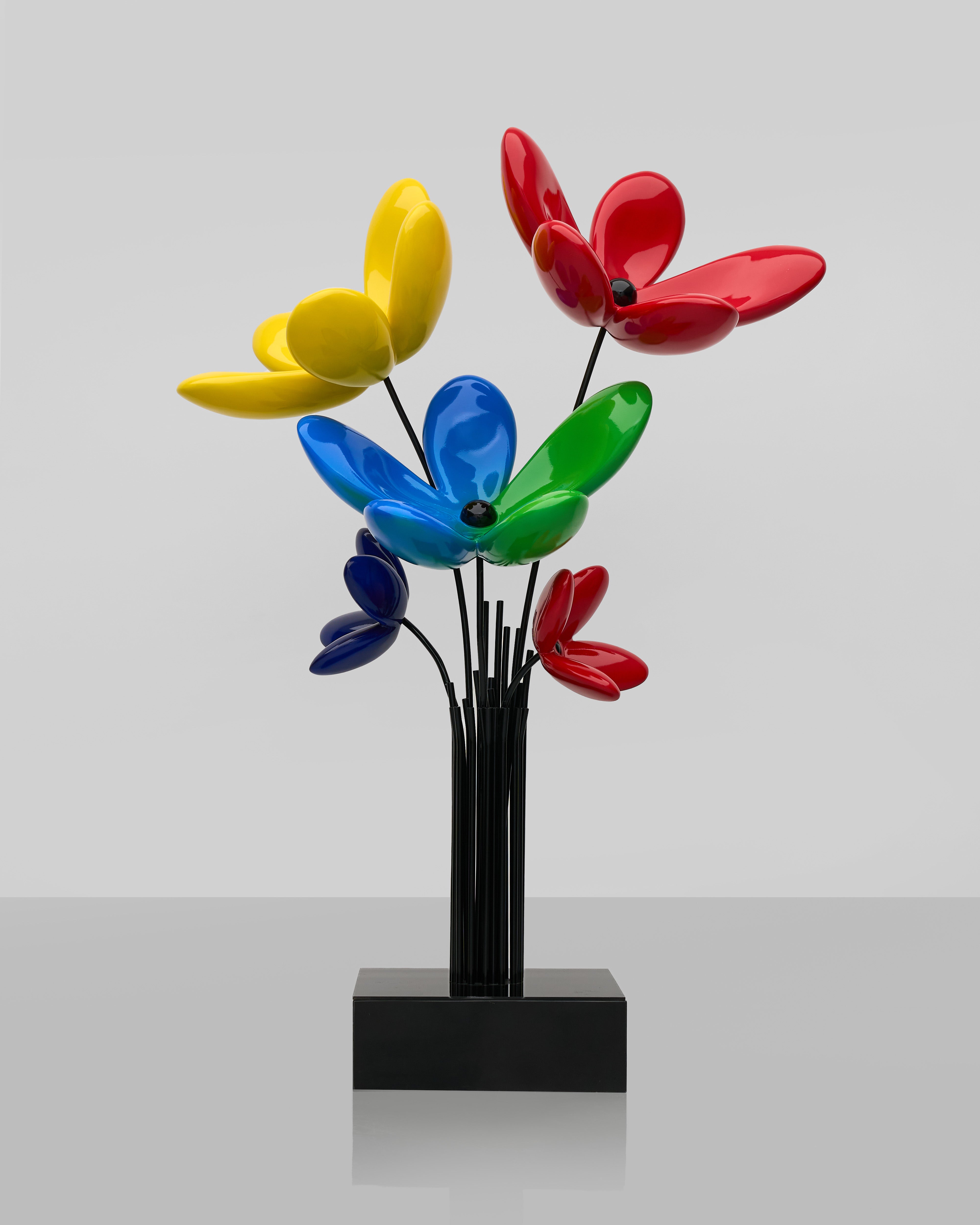 Colorful flower-shaped objects on a black stand against a light gray background