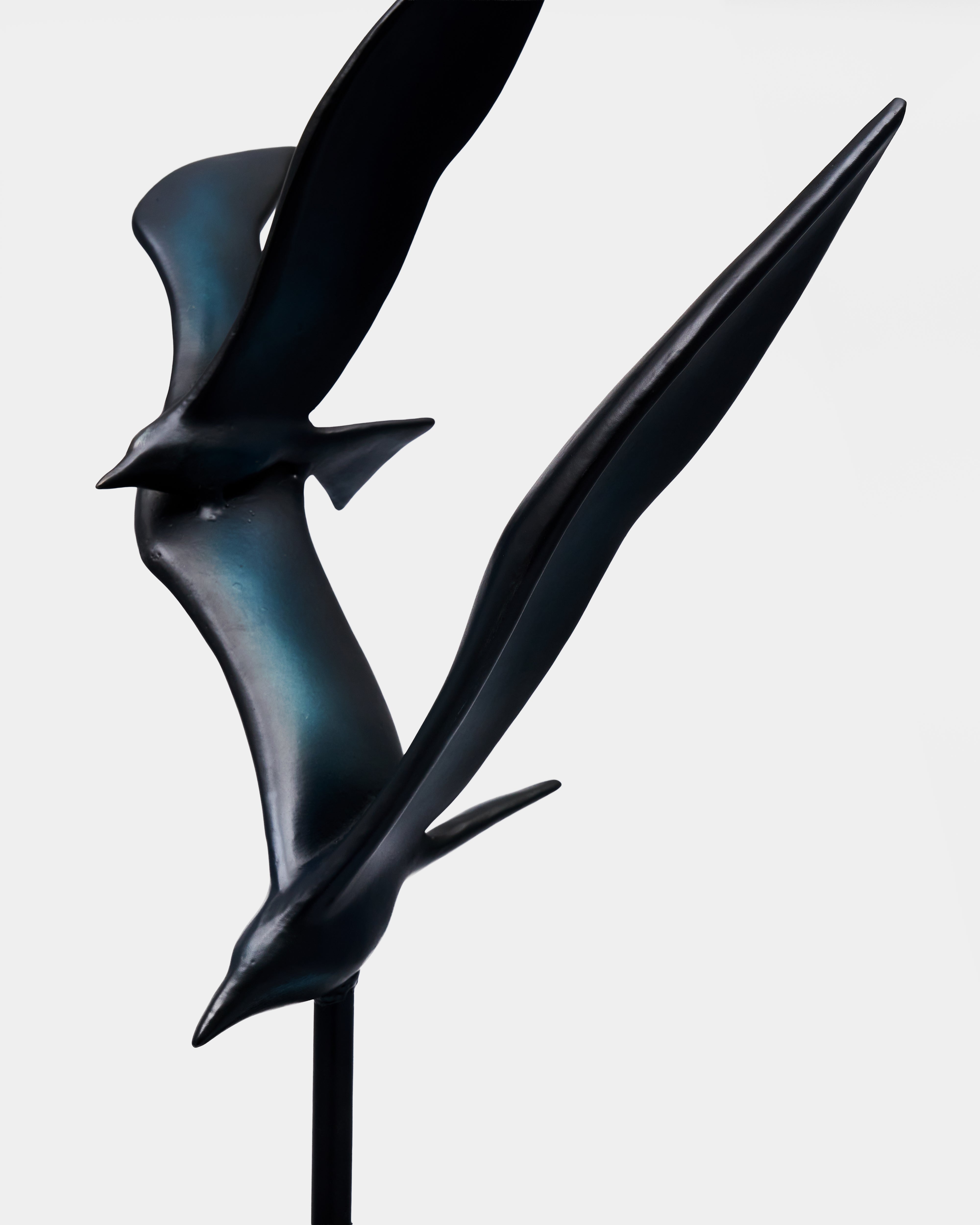 Black abstract bird sculpture on a white background