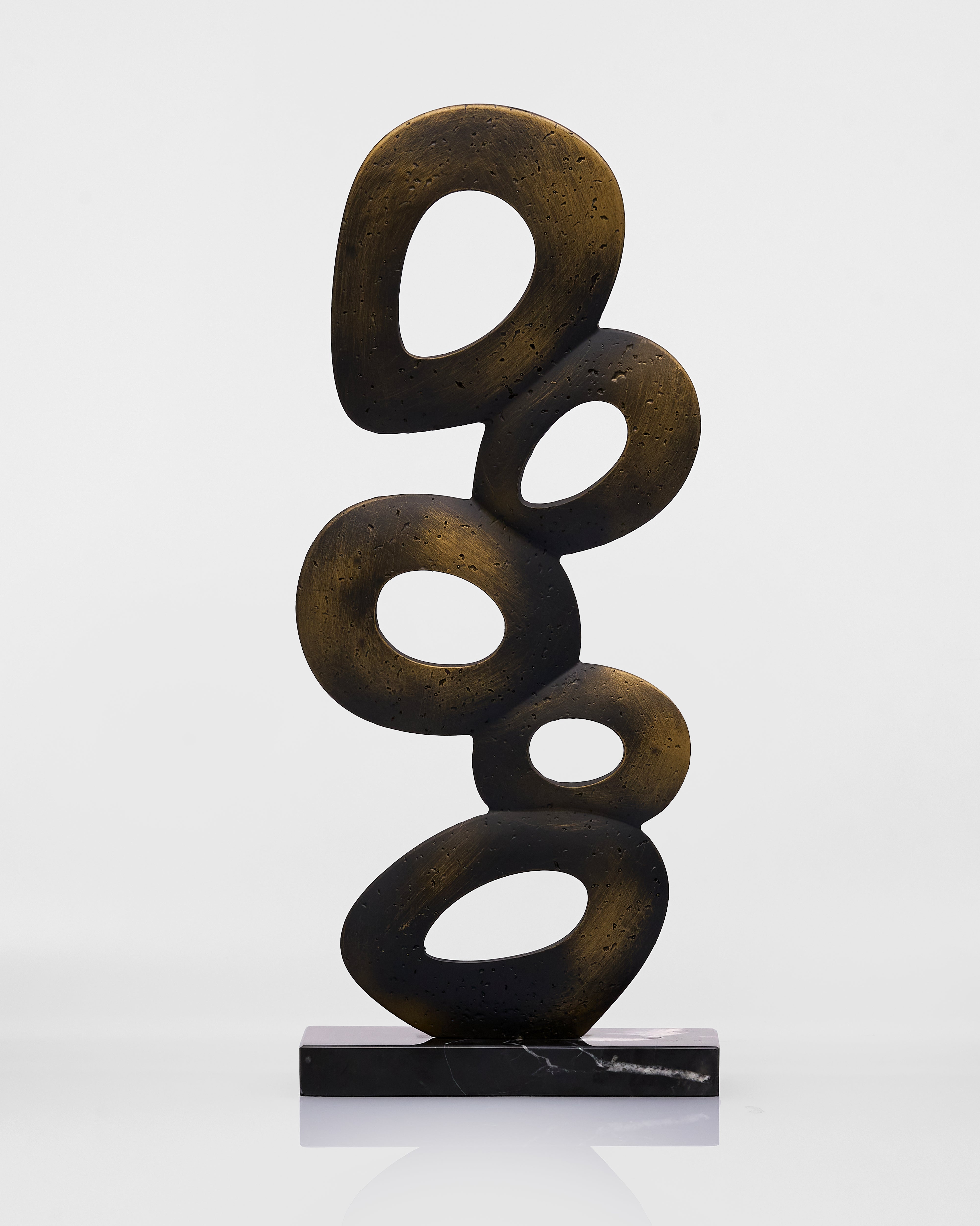 Abstract sculpture of stacked circular forms on a white background