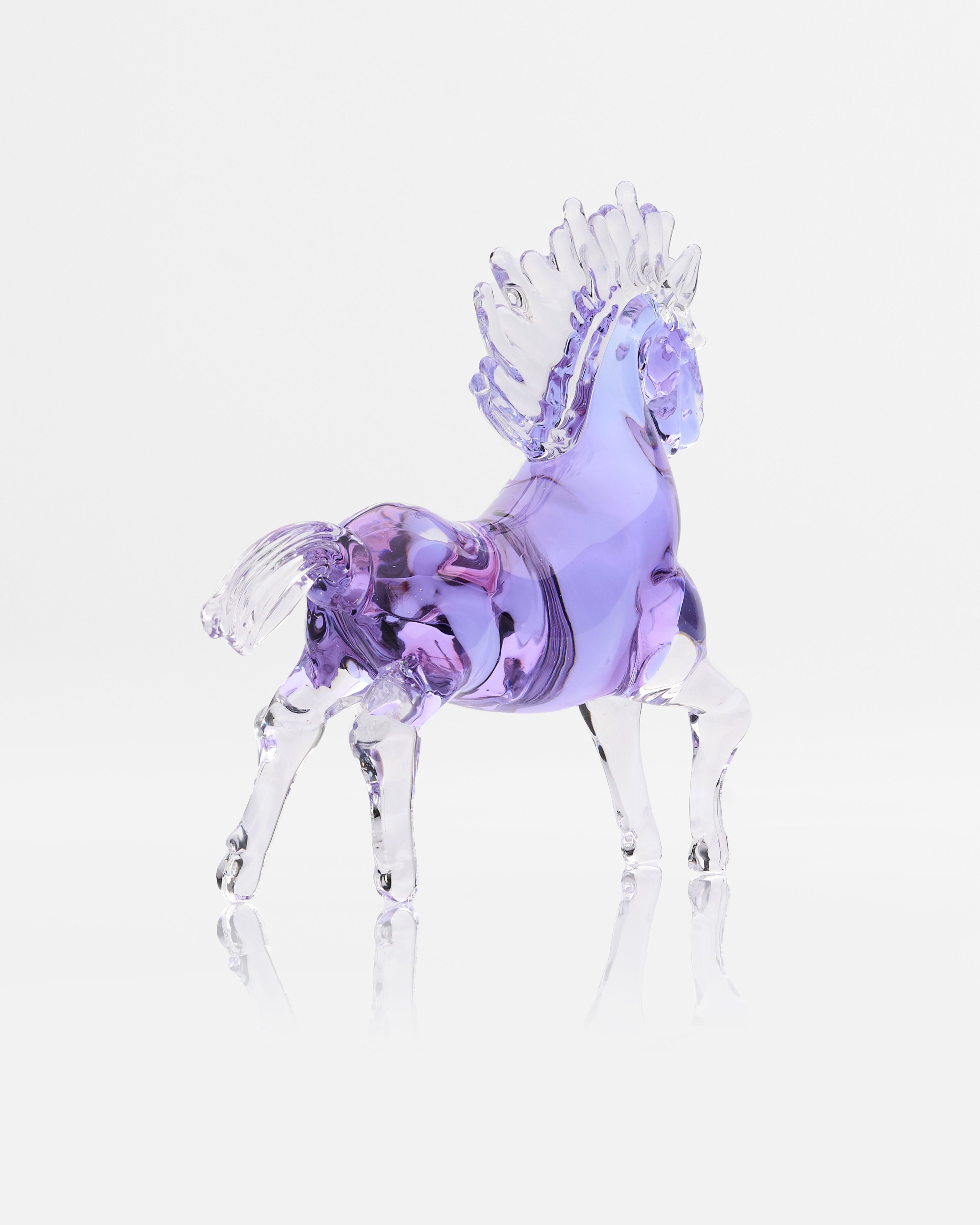Glass horse figurine with a purple body on a light gray background