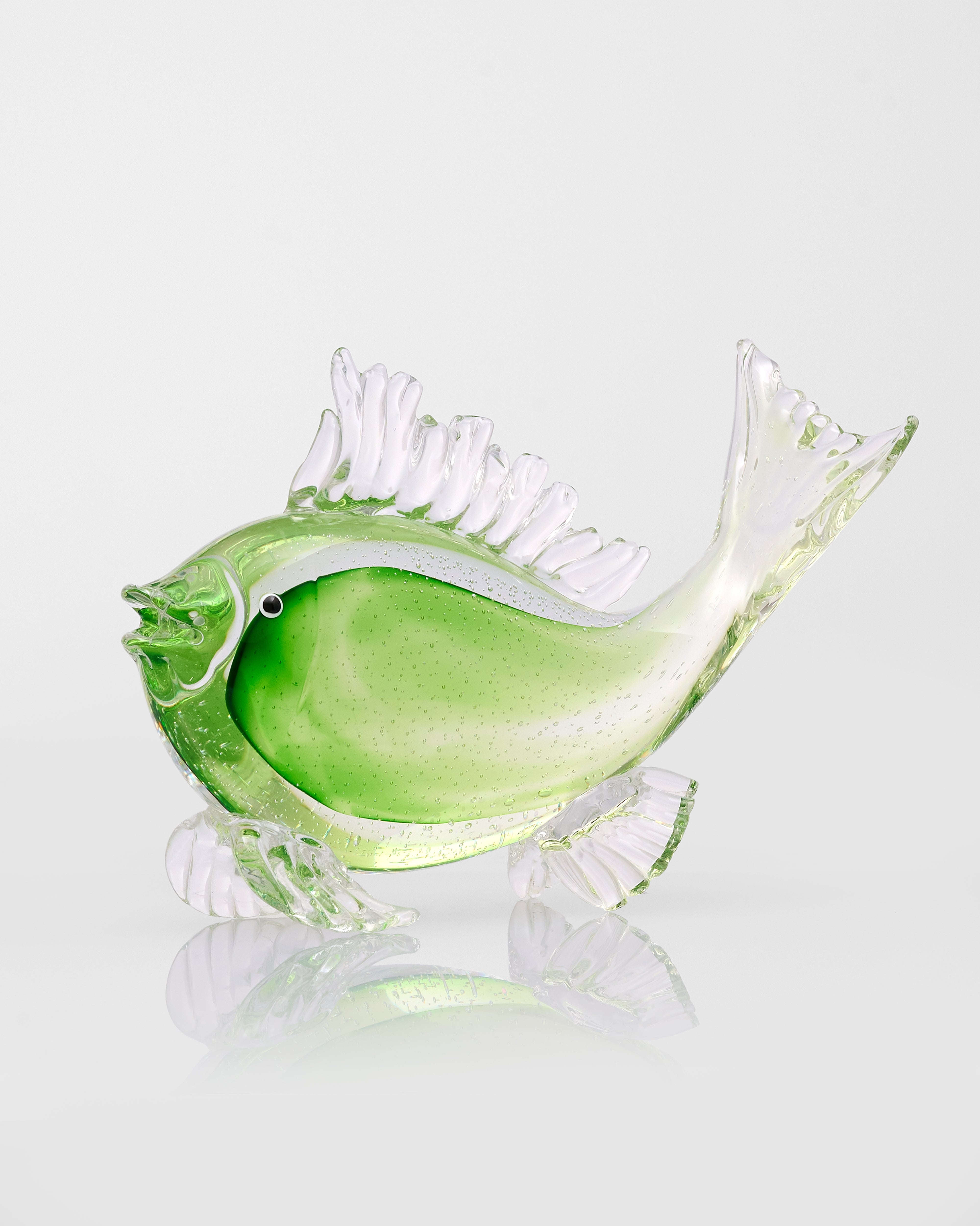 Green glass fish sculpture on a white background