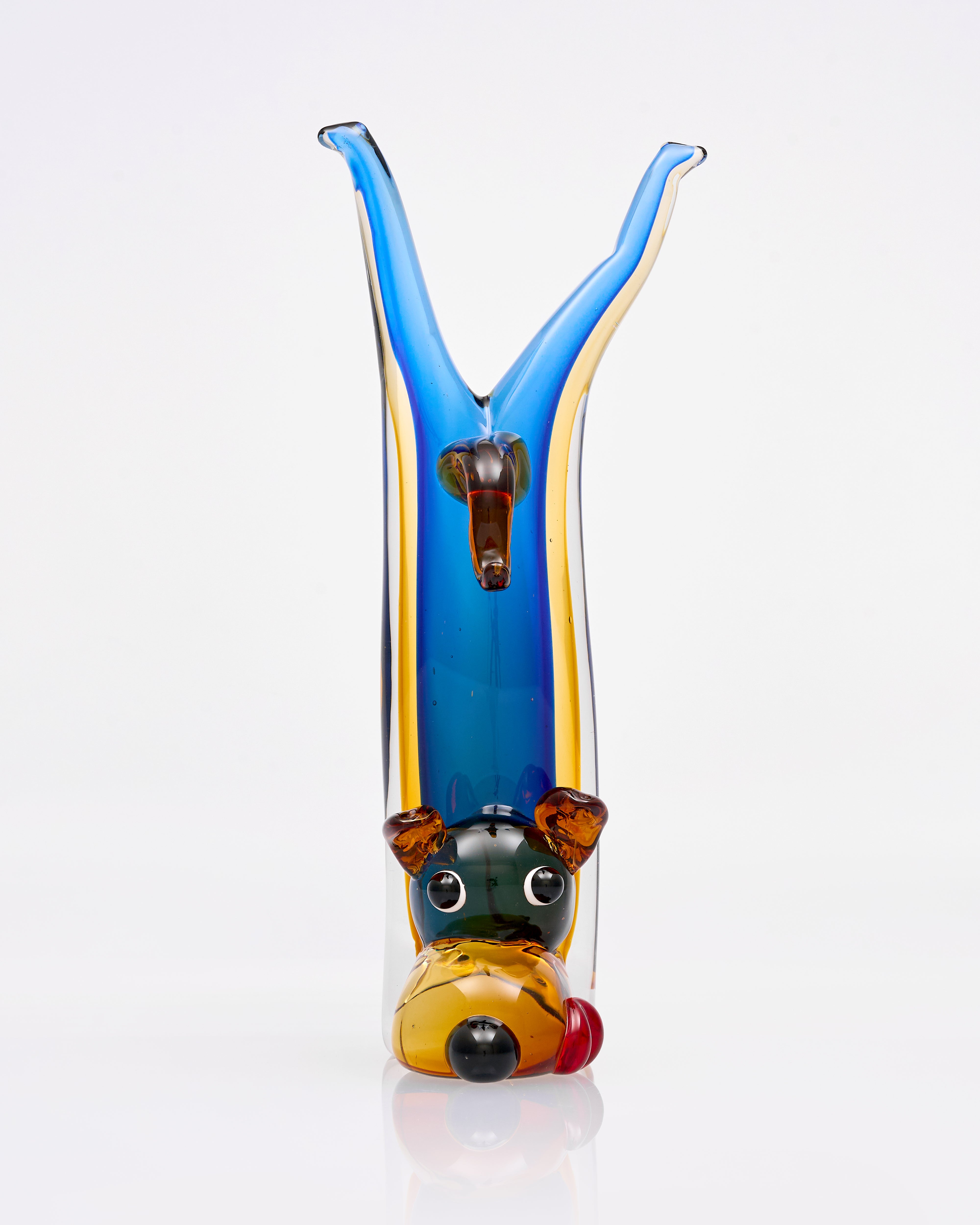 Colorful glass sculpture of a dog with a blue and yellow background
