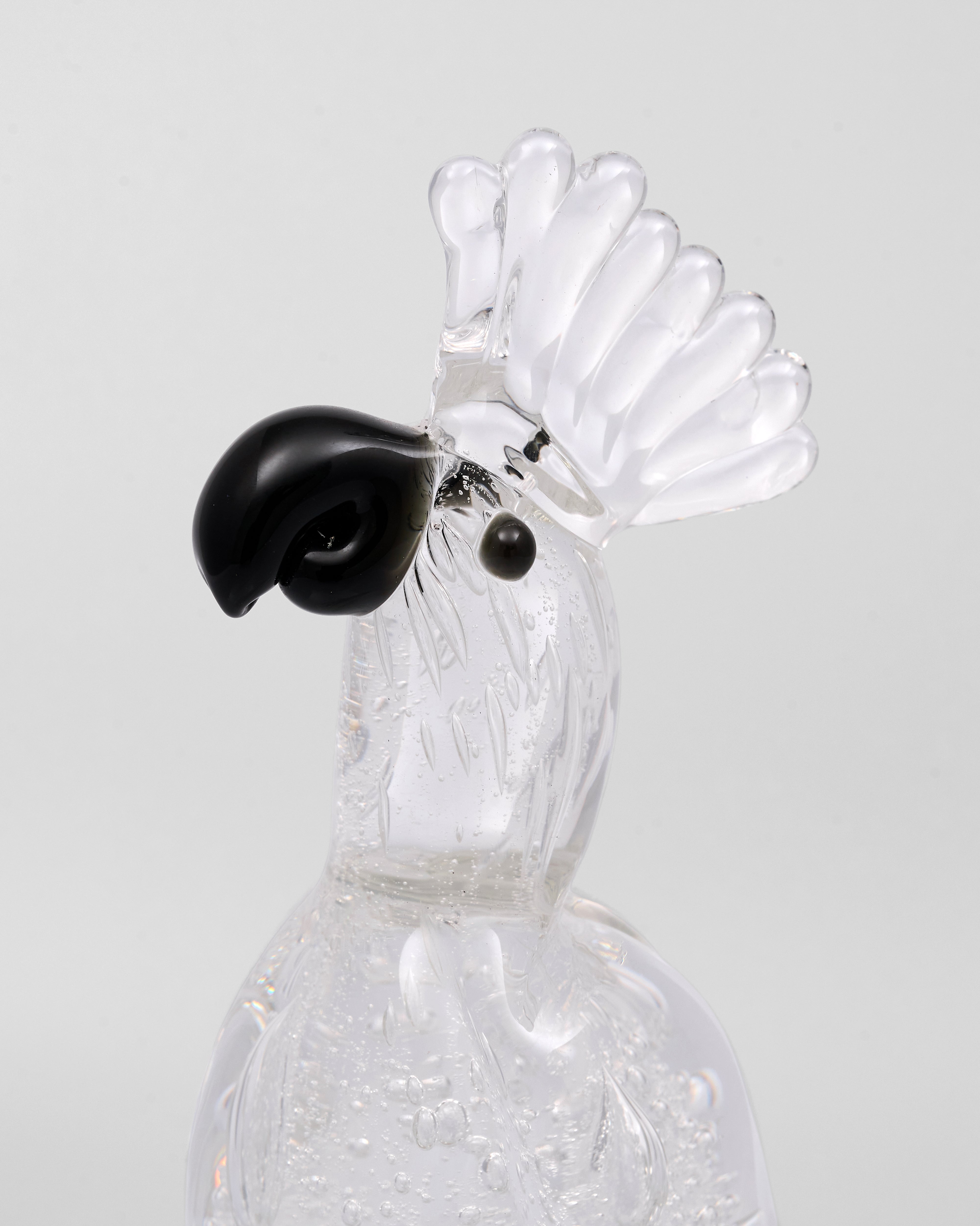 Glass rooster figurine with black comb on a light gray background