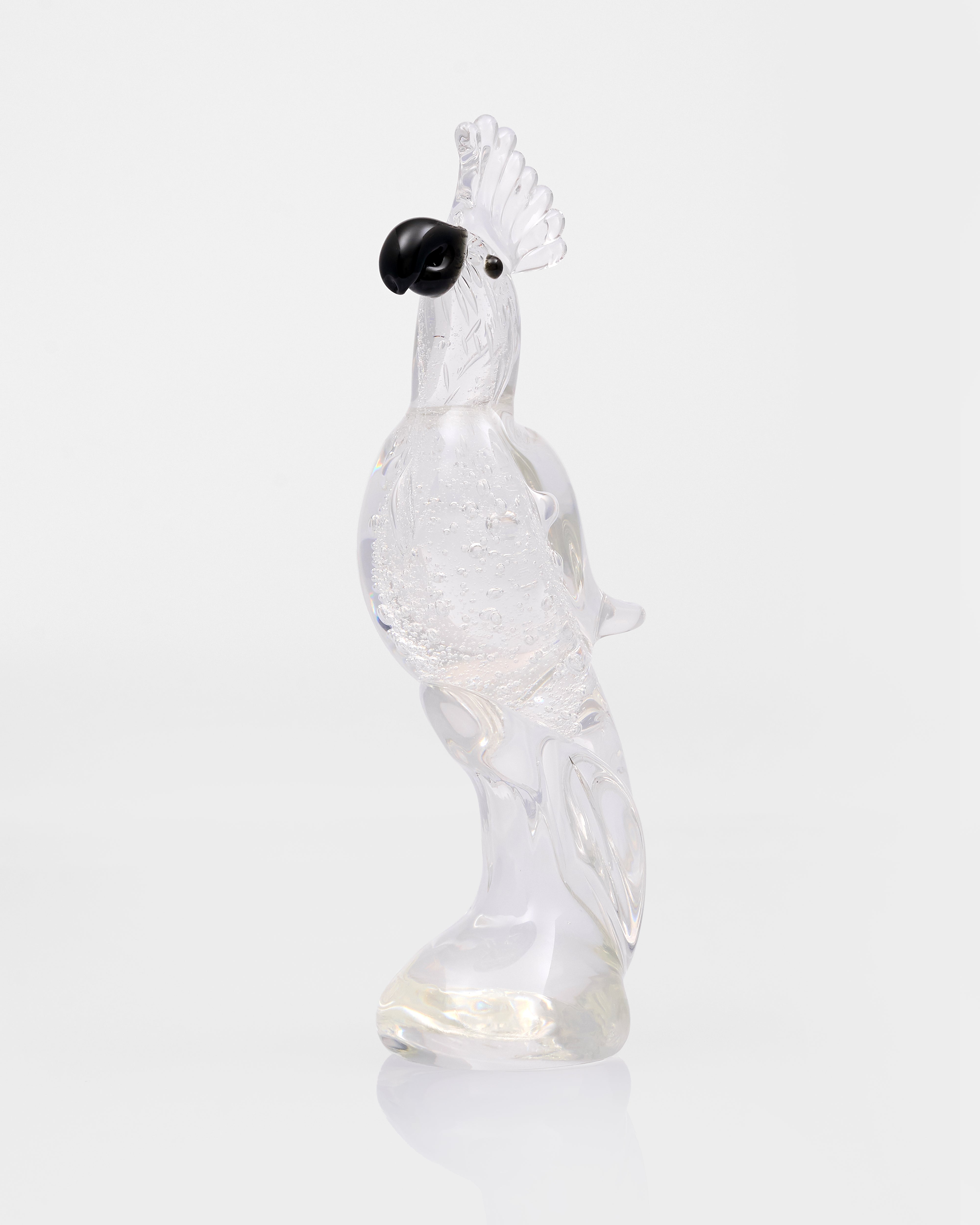 Clear glass parrot figurine with black beak on a white background