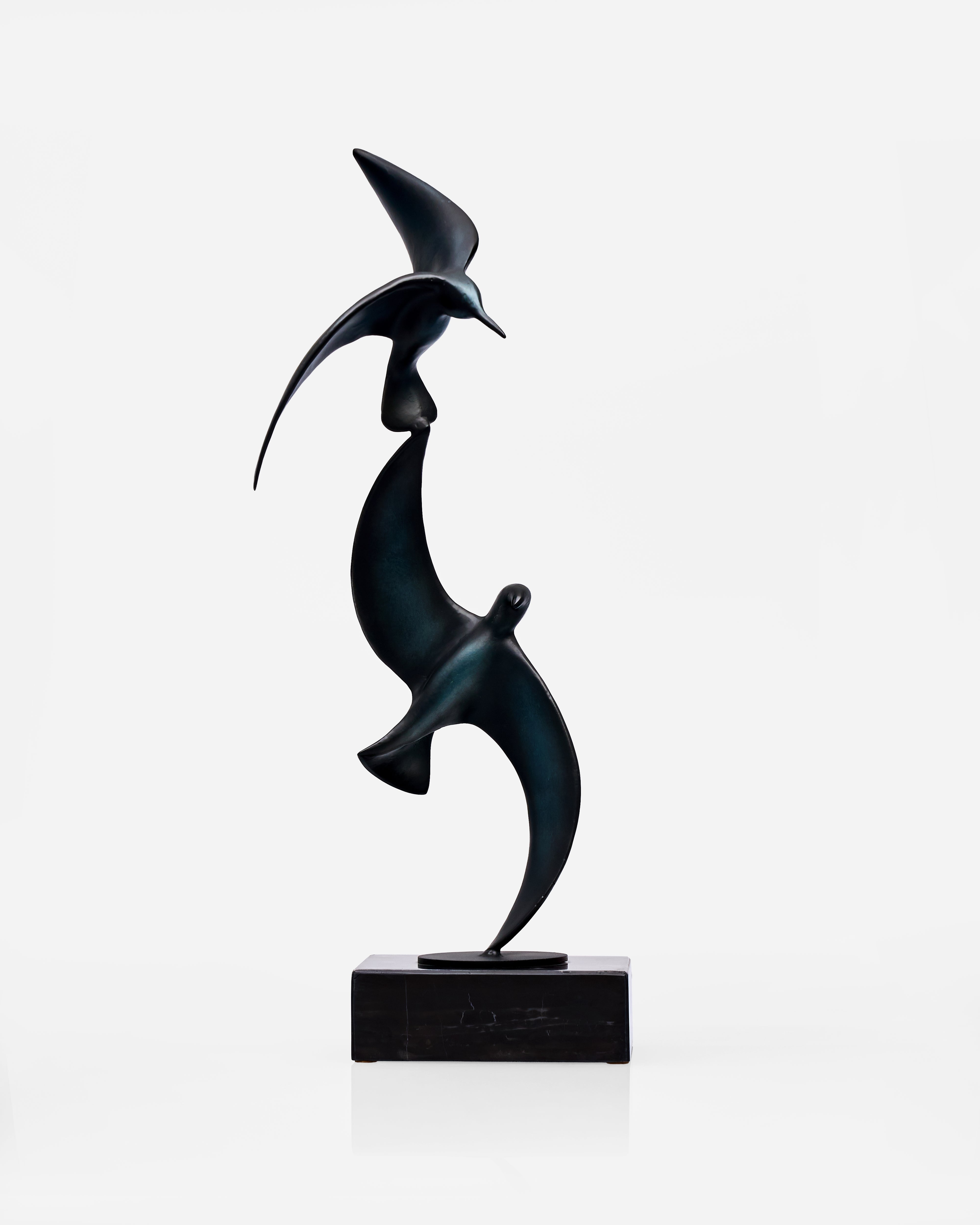 Abstract sculpture of two birds made in metal on a white background