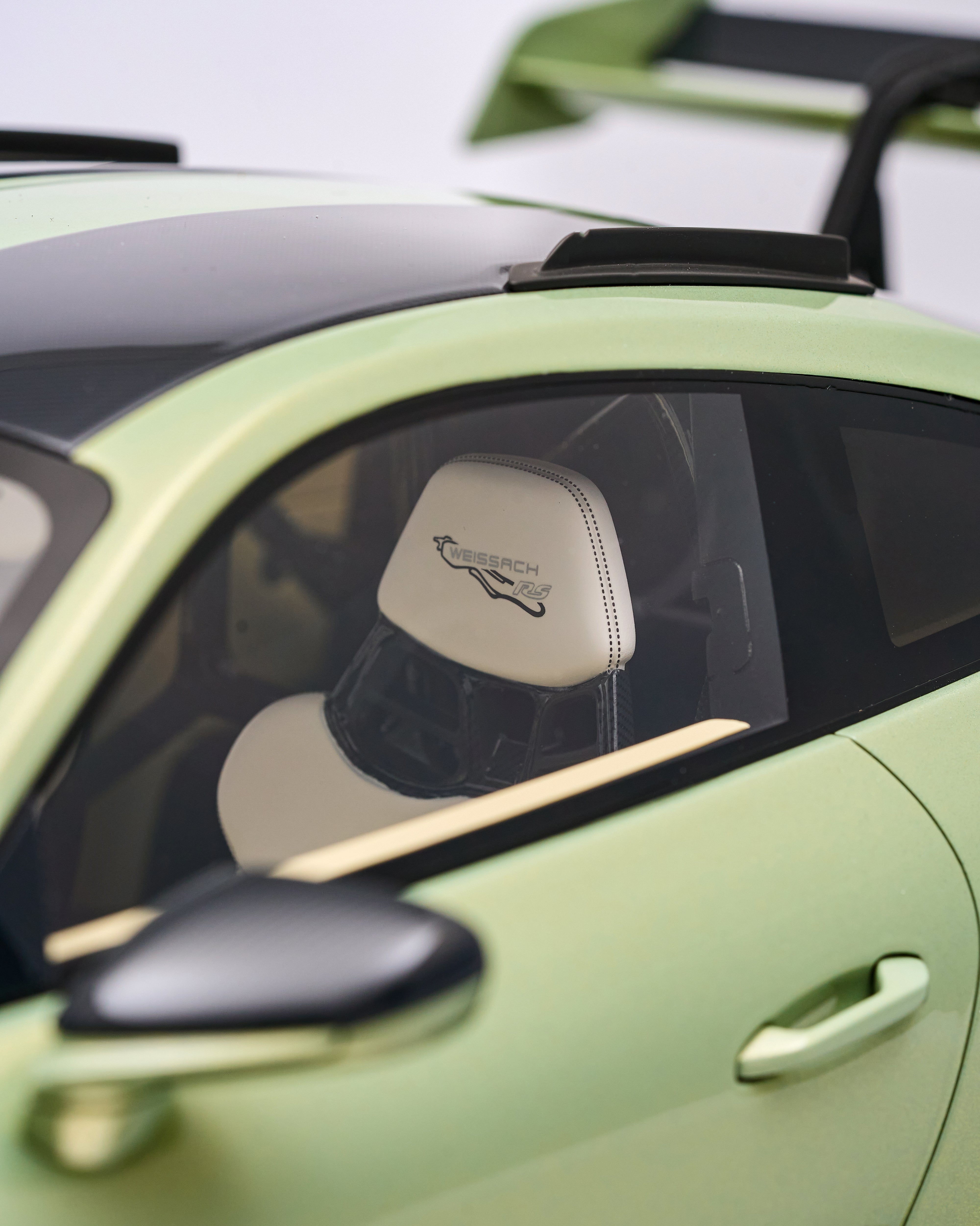 Close-up of a lime green car with a white interior, featuring the 'Jaguar' logo.